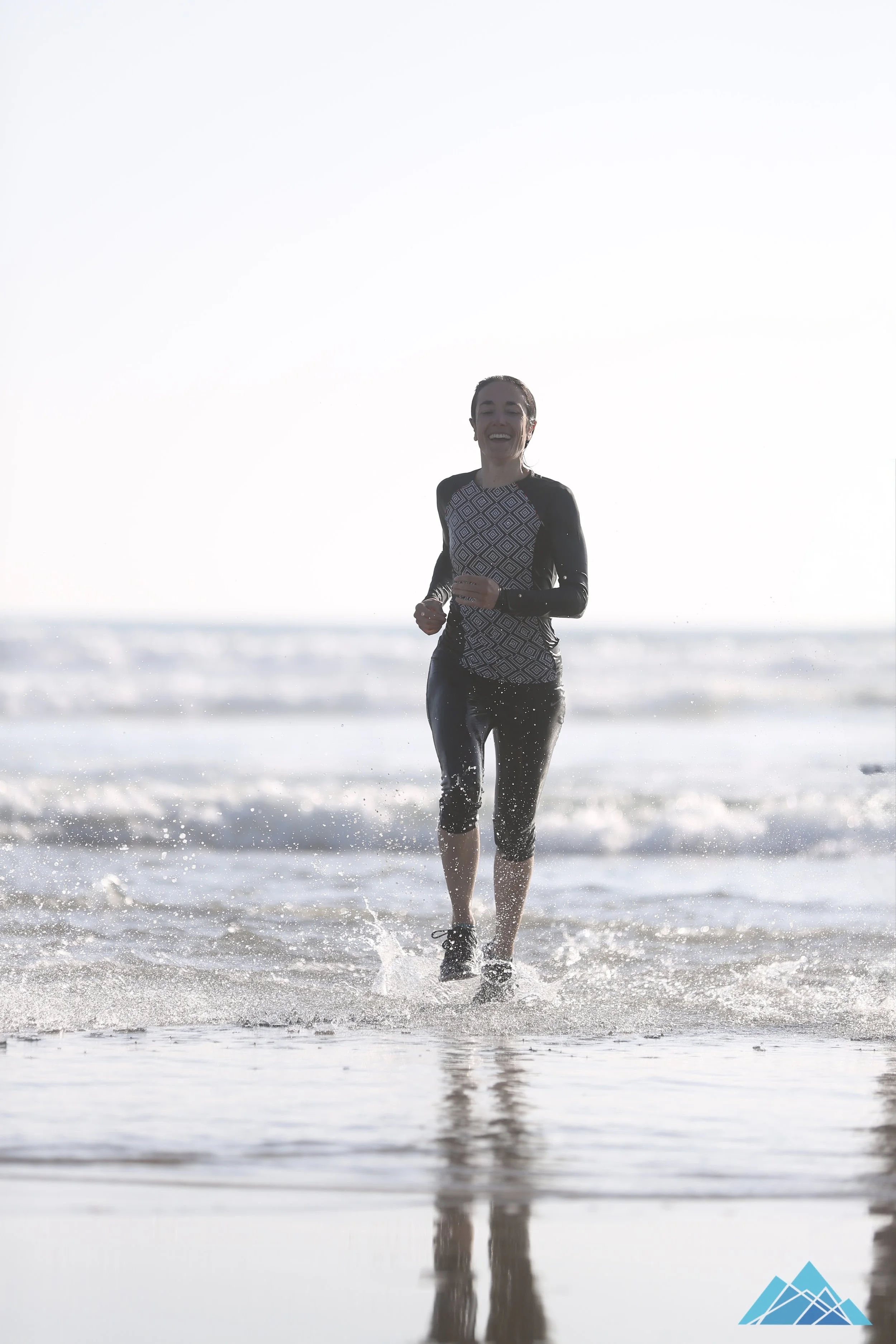 Pauline smiling as she runs out of the surf