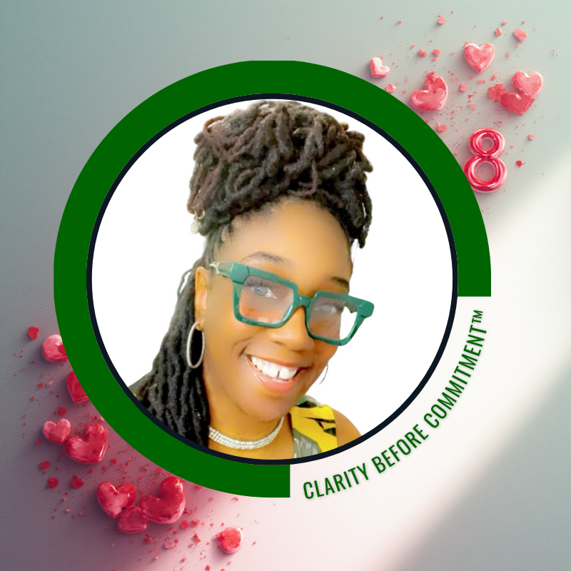 Close-up of smiling woman with styled dreadlocks wearing glasses, hoop earrings, and a yellow top, in an office with whiteboard and trophies in the background.