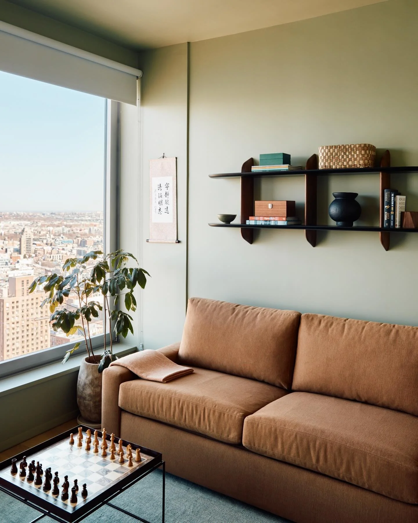 Added a little something something to make this spot more hangoutable

This home office setup does a lot! A pullout sofa bed for guests, a permanent home for a favorite chess set, a wall shelf that doubles as a video call backdrop, meaningful art, a 