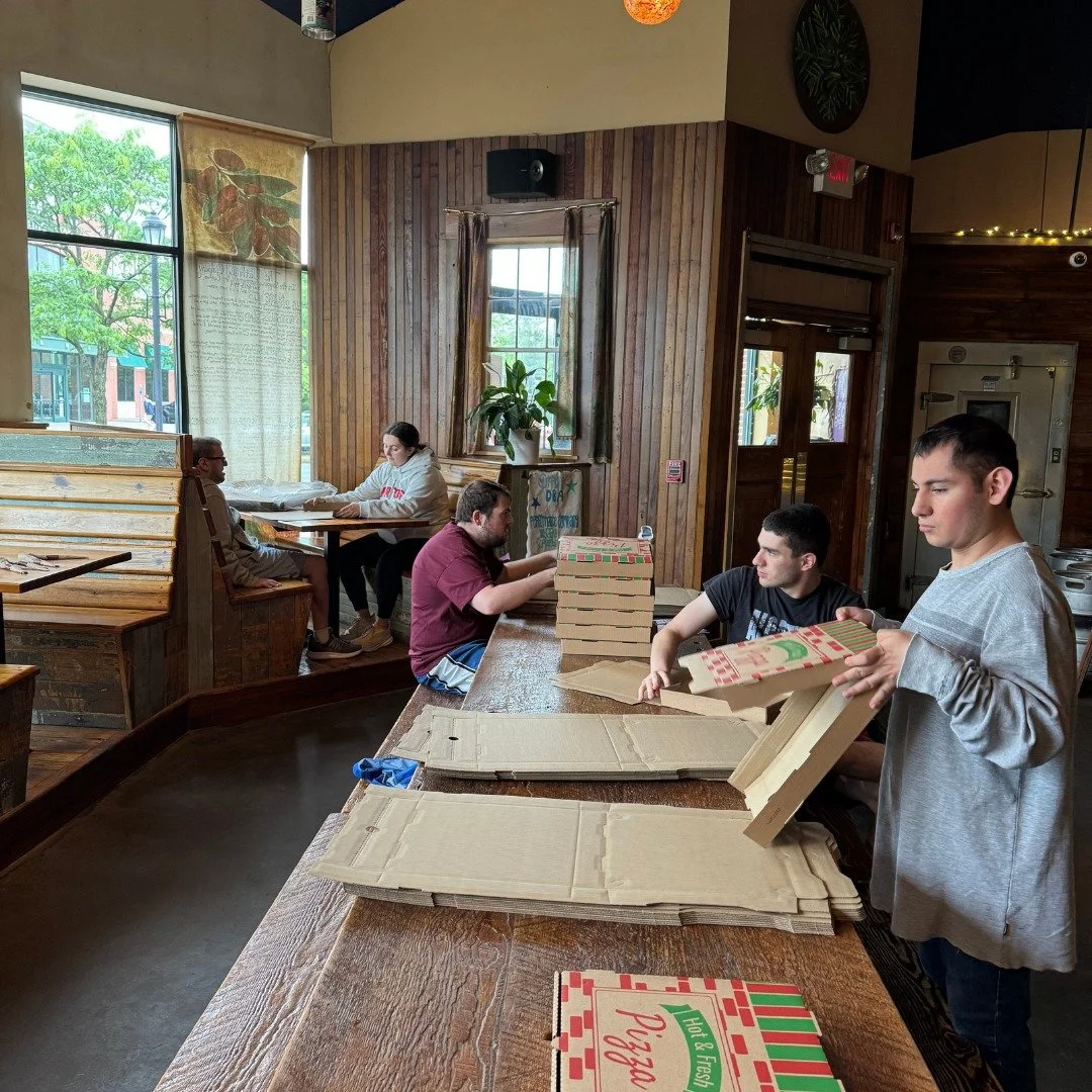 Individuals folding boxes at a community restaurant.