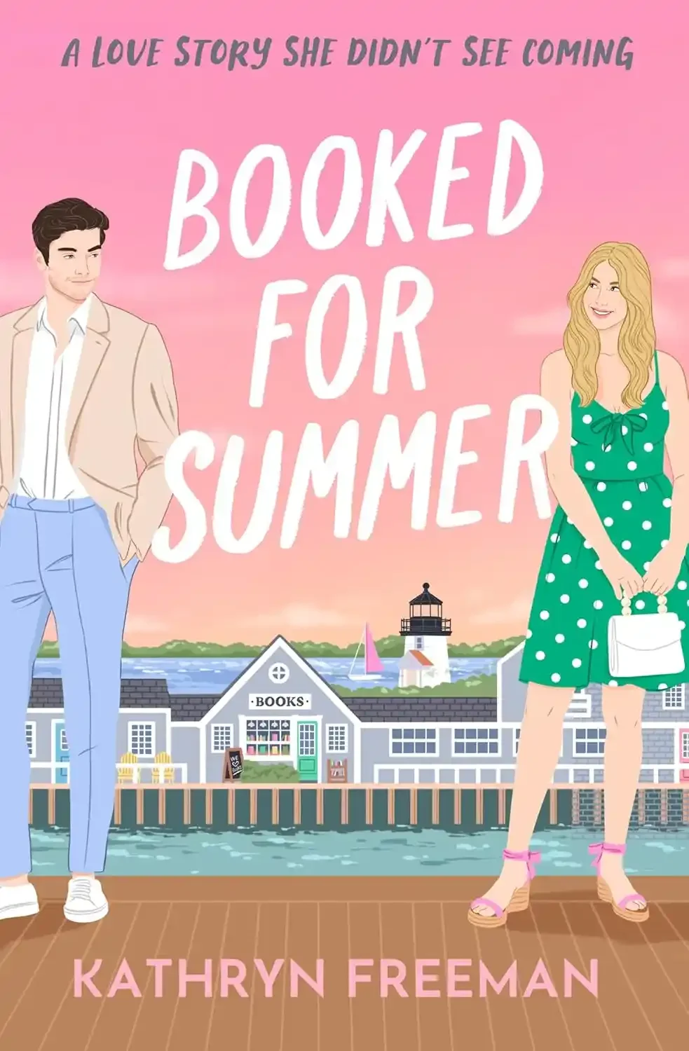 Book cover for "Booked for Summer" by Kathryn Freeman, featuring a man in a beige jacket and light blue pants, and a woman in a green polka dot dress with pink heels, standing on a wooden dock with water, a lighthouse, and buildings with a bookstore in the background, during sunset.