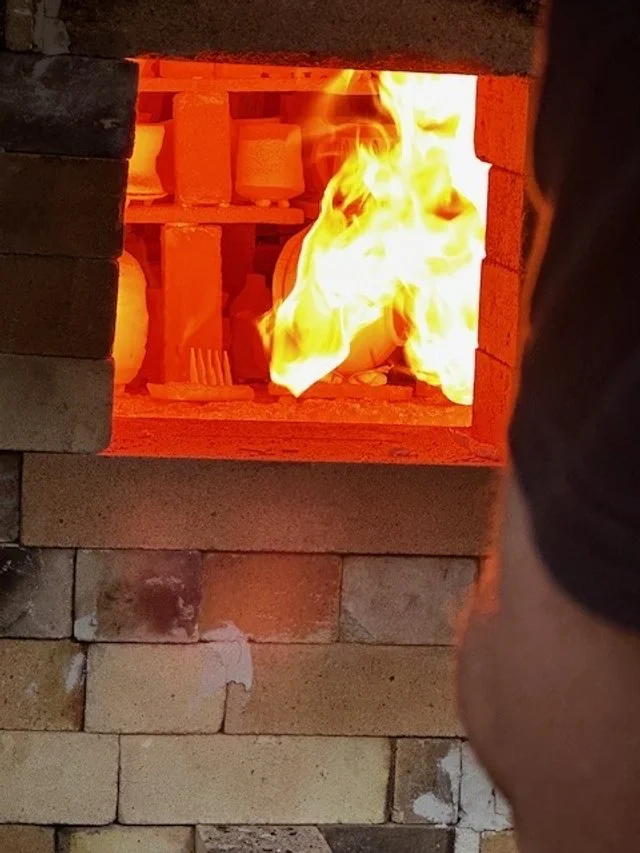 A brick oven with a fire burning inside, used for baking or heating.
