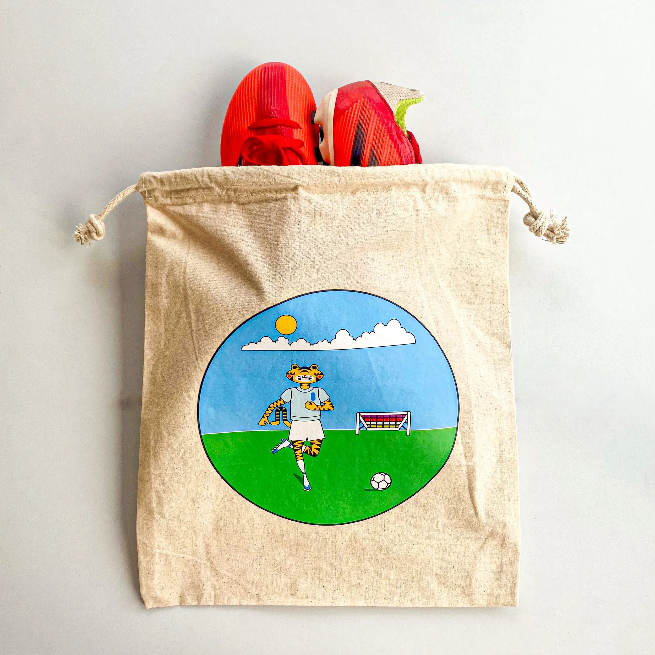 Photo of printed logo tote bag with a pair of shoes stacked into it.