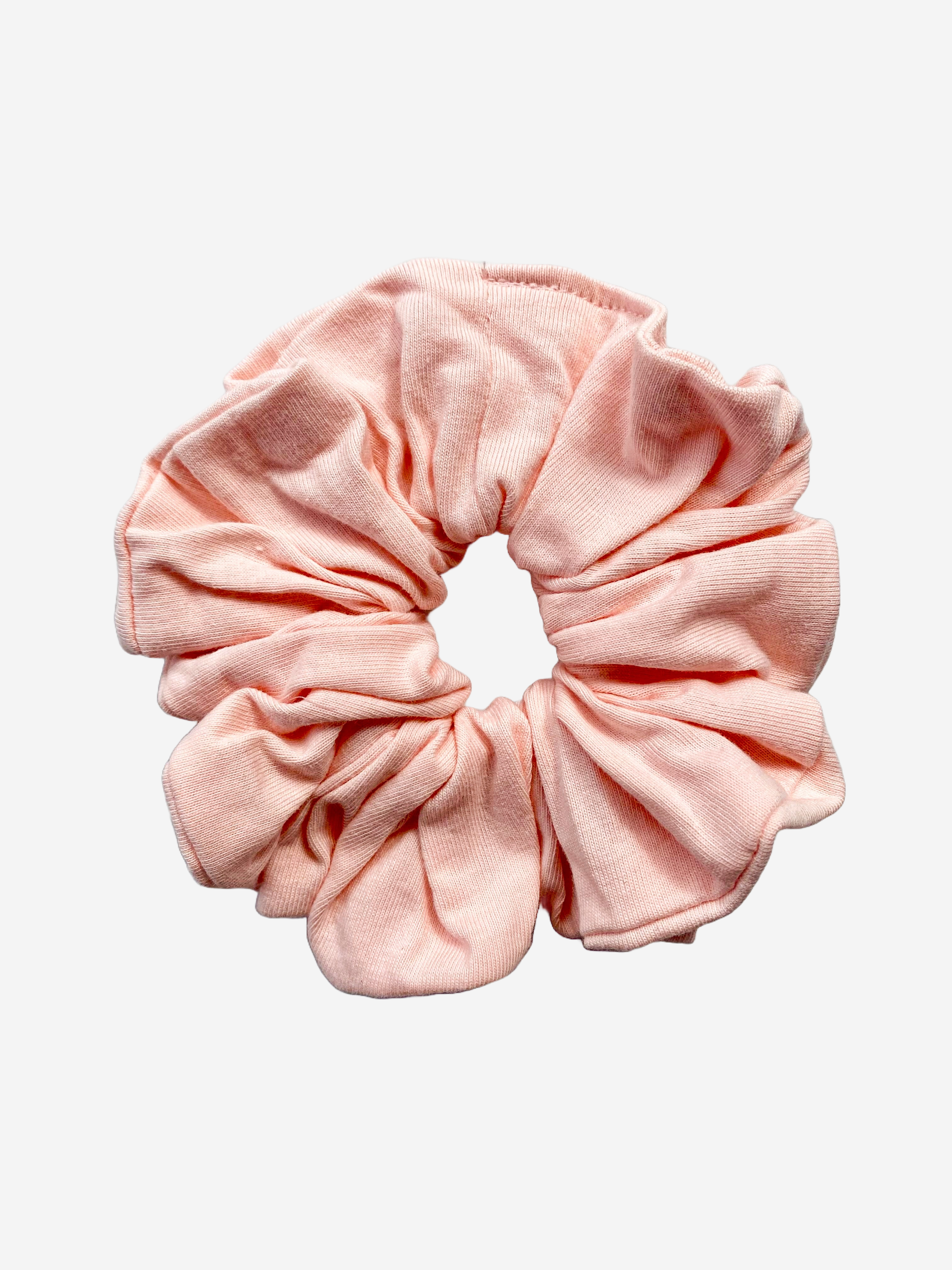 A pink fabric scrunchie on a white background.