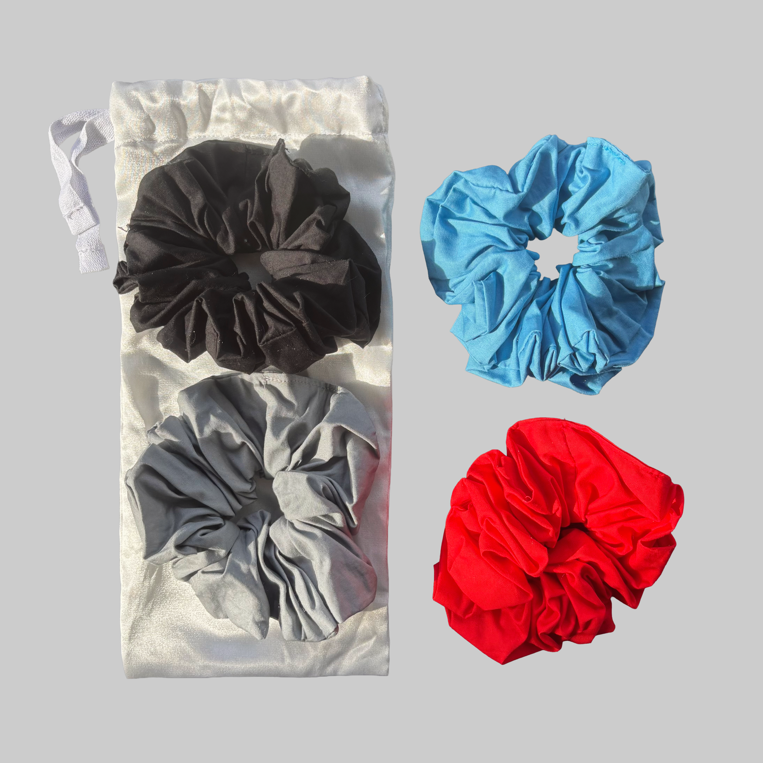 Assorted coloured scrunchies consisting of black, grey, blue, red, and white.