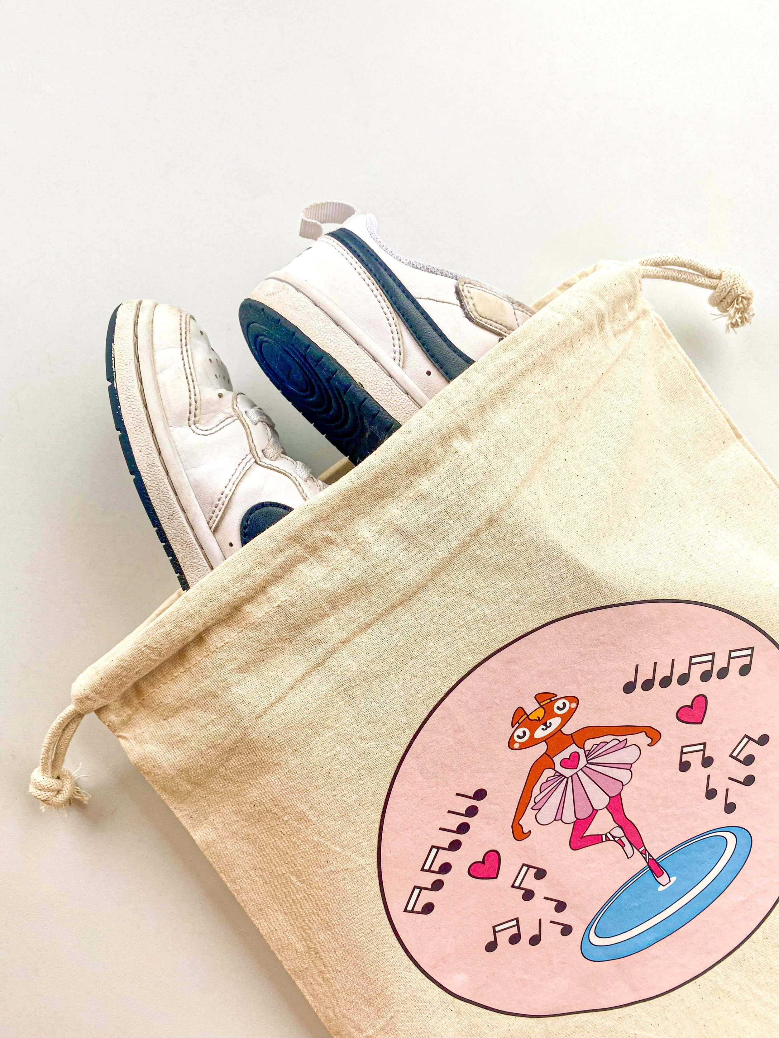 Close up detail of printed ballerina bag with a pair of shoes stacked into it.