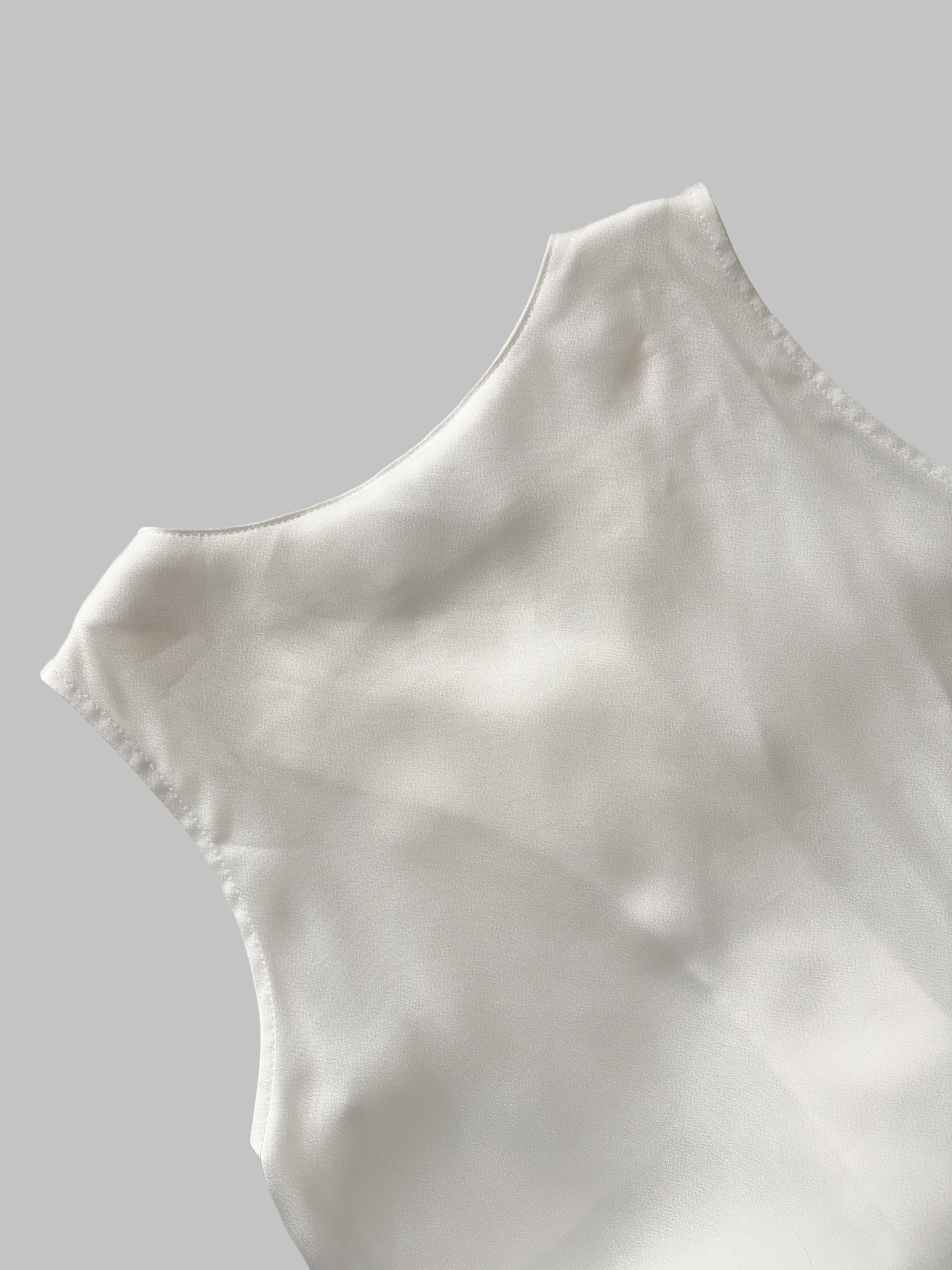 Close-up of white satin dress with a smooth and shiny texture.