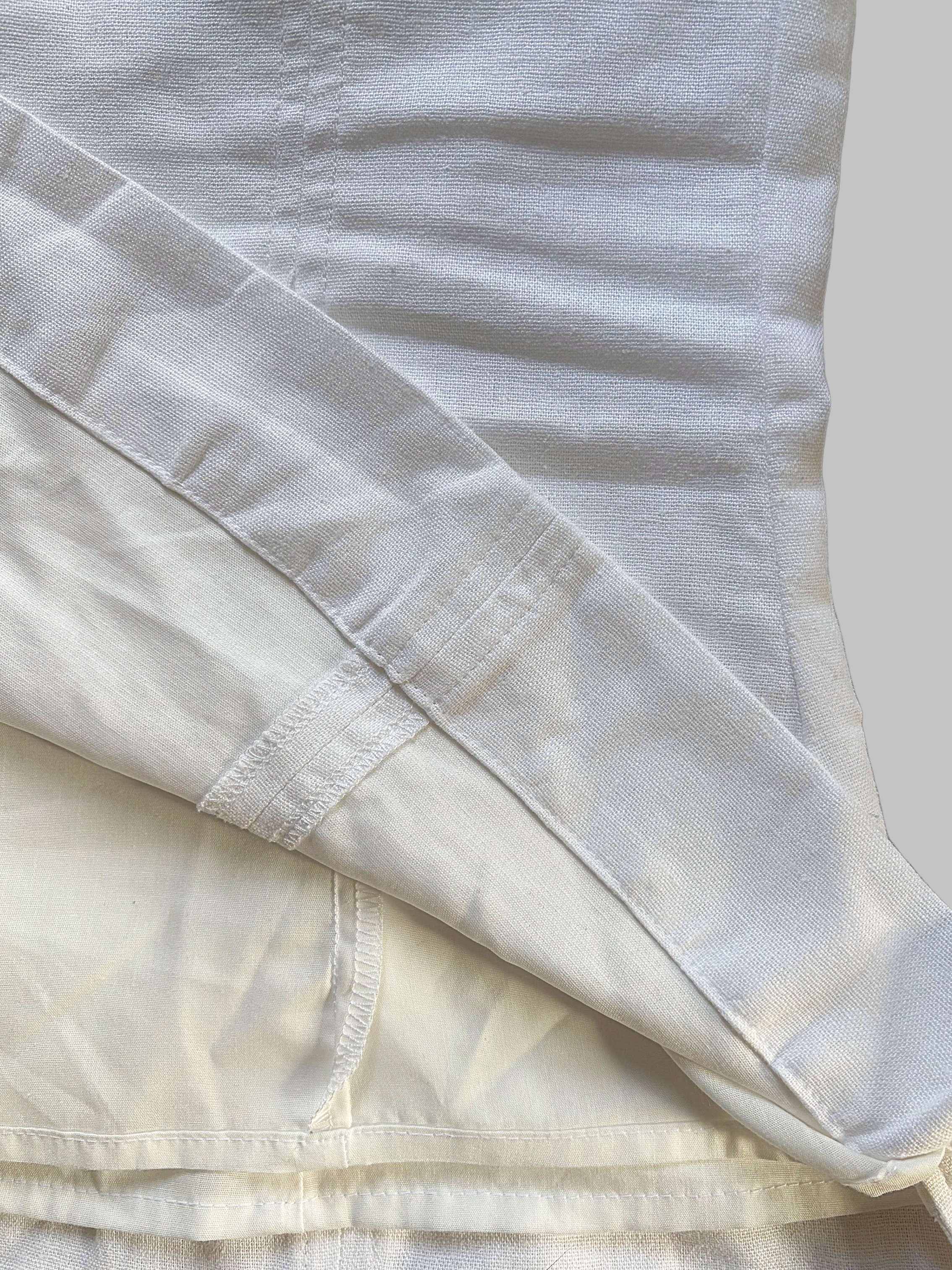 Close-up of layered top with visible seams and hem stitching.
