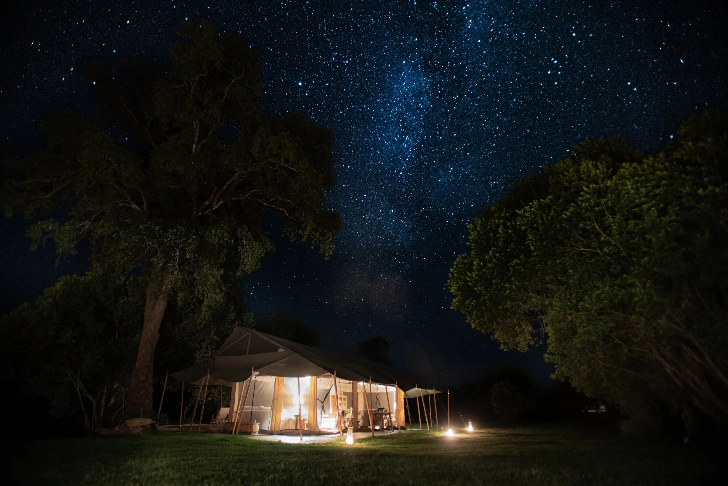 Evenings at camp, lit by lanterns below and constellations above.