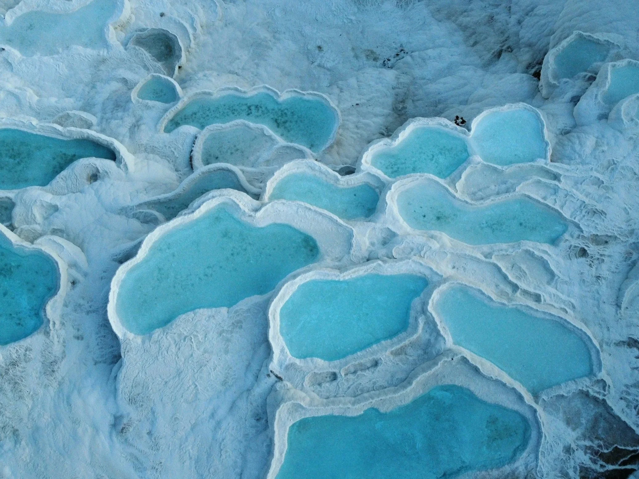 White travertine terraces of Pamukkale Turkey, known for natural thermal formations and a calm scenic environment.