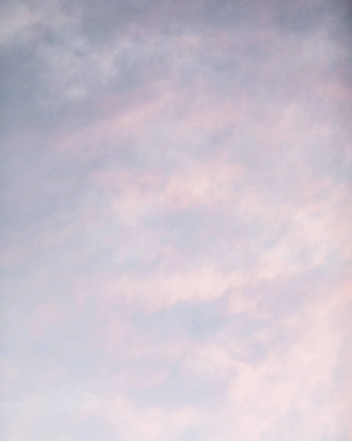 A clear sky with soft pink and blue clouds.