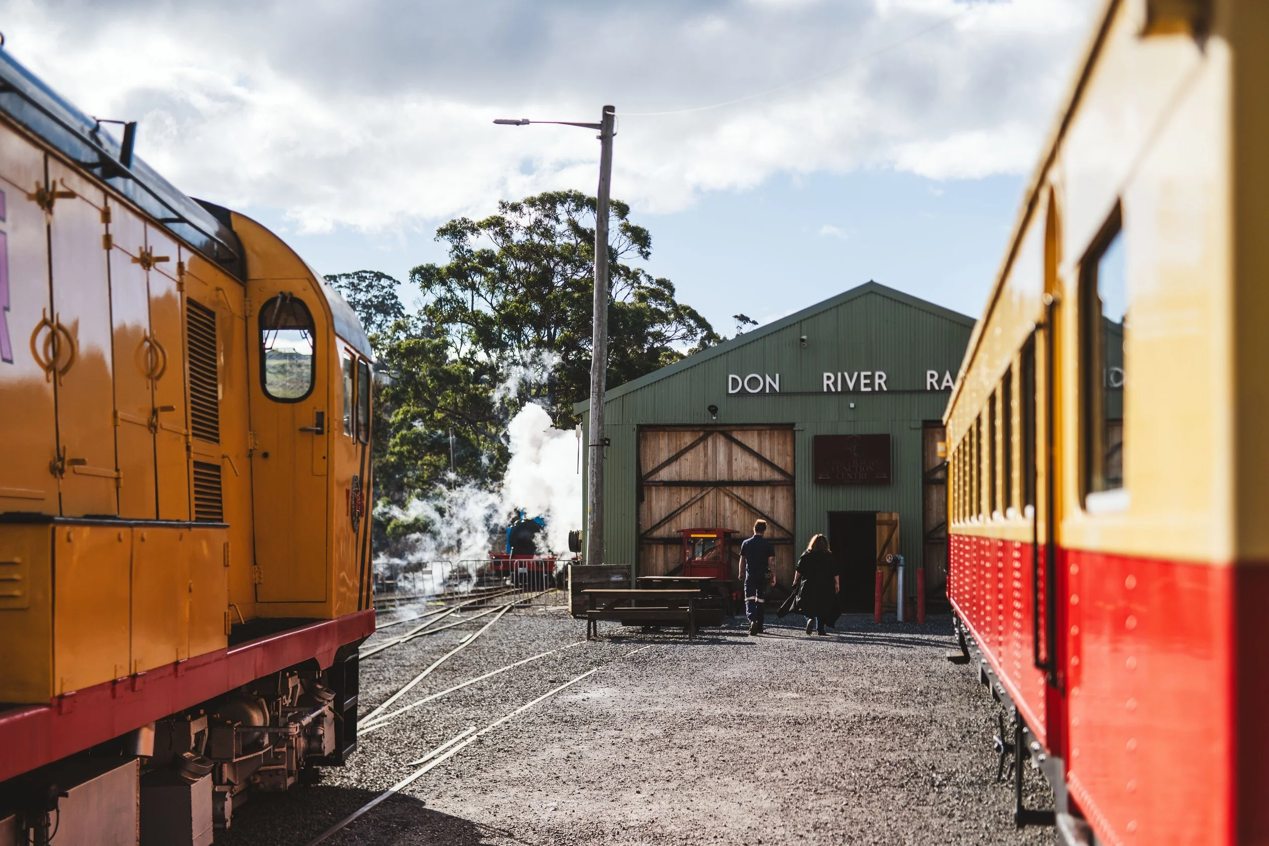 Vintage trains at heritage railway station with steam rising in rural Australia
