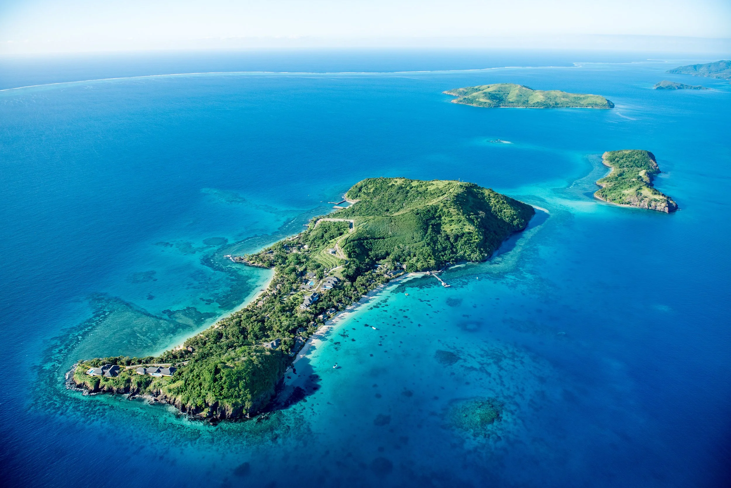 Aerial view of private tropical island surrounded by turquoise ocean in the South Pacific