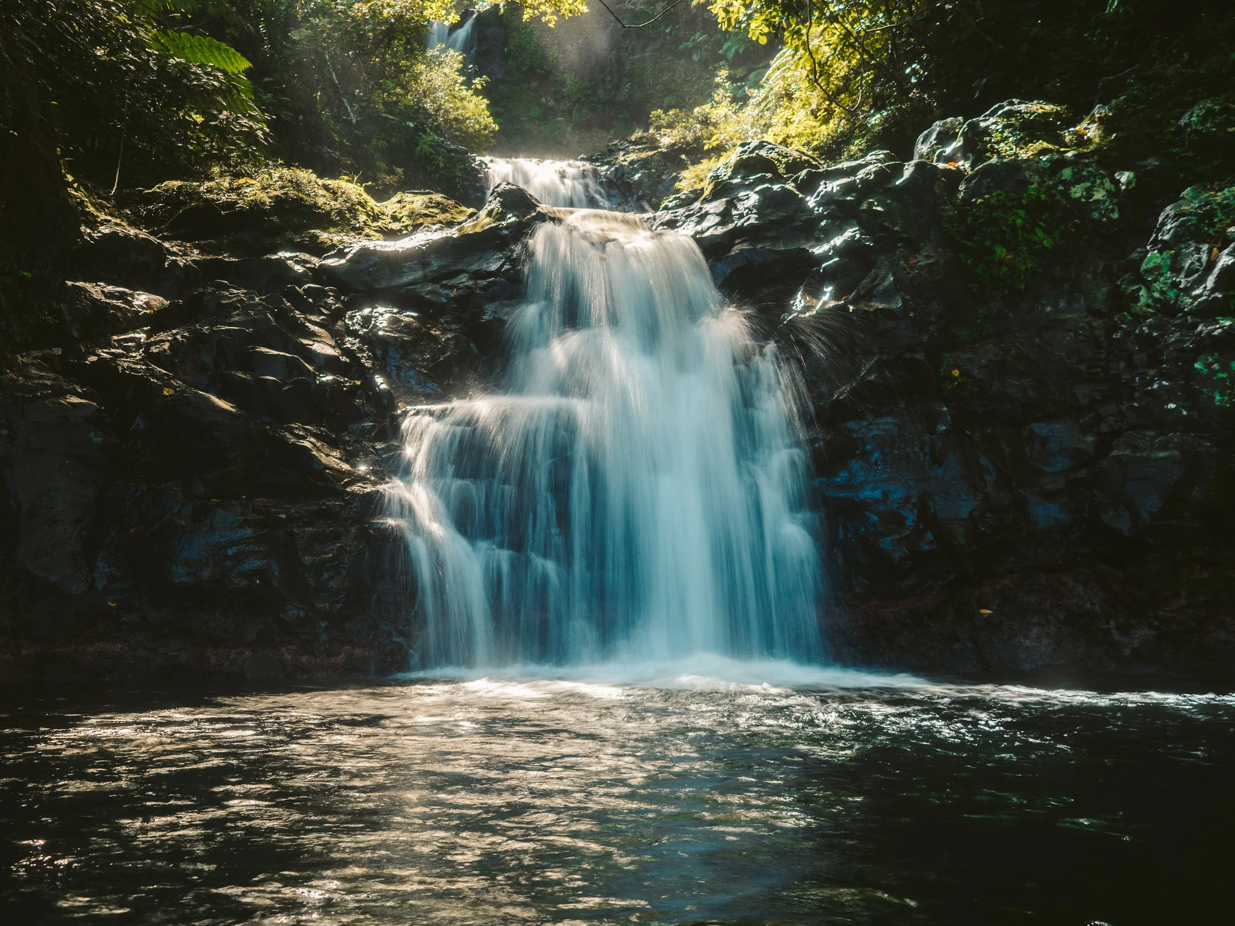 View of isolated water in the mountains with rocks and waterfall