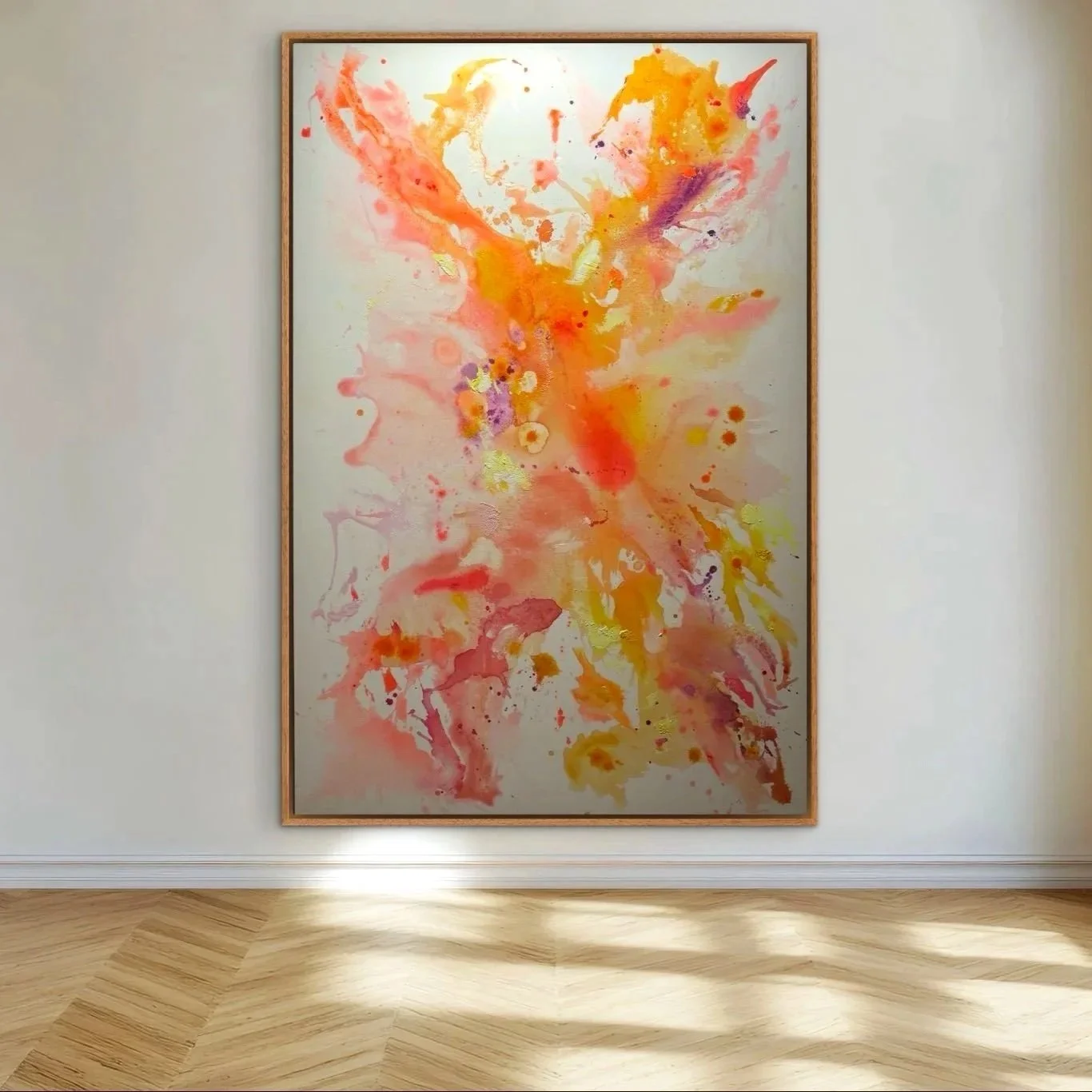 Ein abstraktes Gemälde mit warmen Farben wie Orange, Gelb, Rot, Lila und Pink in einem schlichten Rahmen, hängen an einer weißen Wand in einem Raum mit Holzboden.
