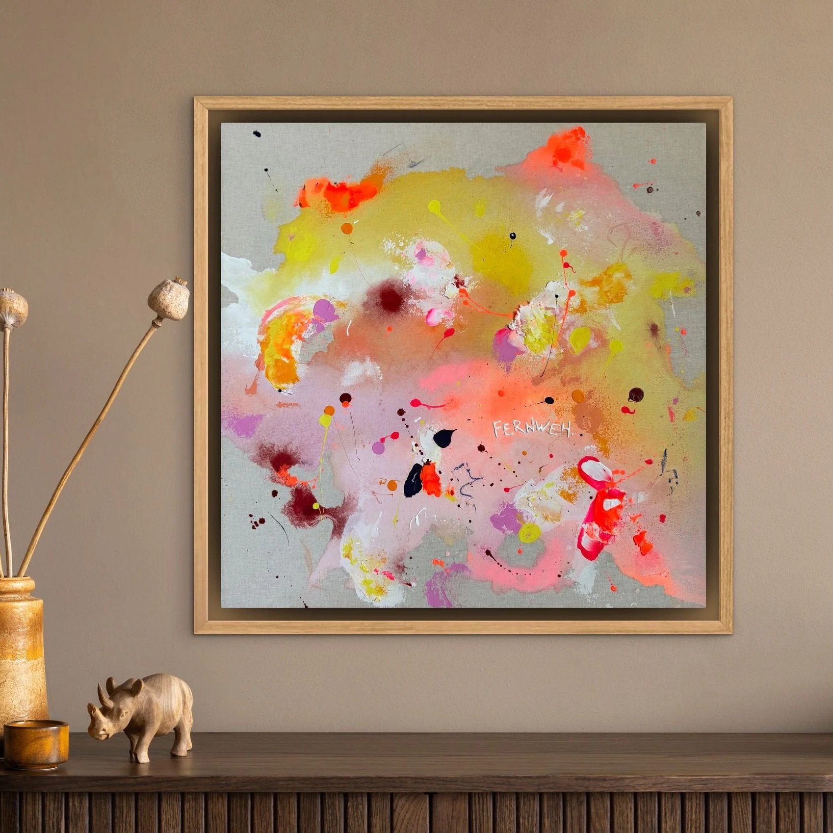 Abstractes Gemälde mit bunten Farbspritzern und dem Text 'Fernweh' in der Mitte, hängt an einer Wand.