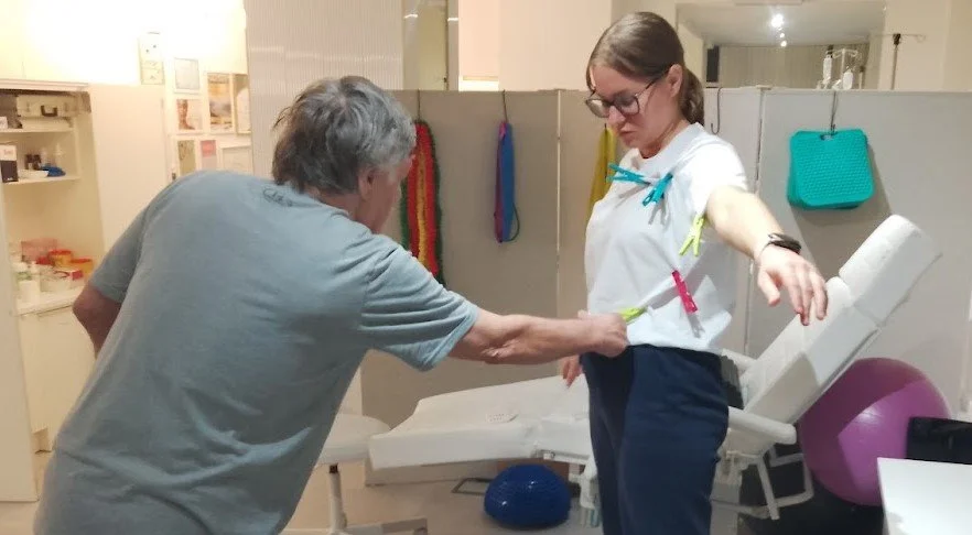 A woman receiving physical therapy from a therapist in a therapy room.