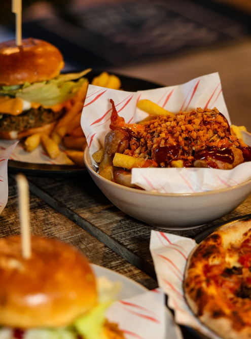 Deep-fried chicken drumstick topped with breadcrumbs, served with French fries and barbecue sauce in a bowl.