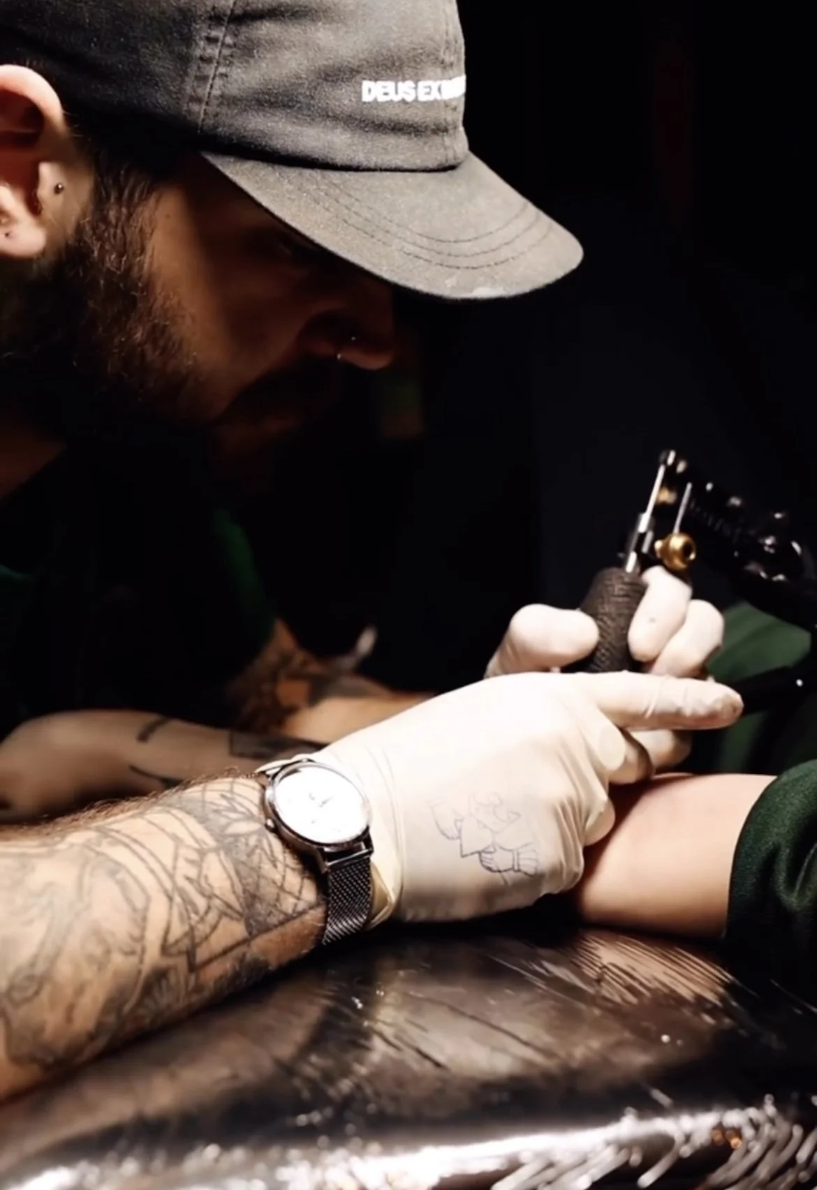 A tattoo artist in liverpool tattoo studio tattooing a piece of flash on client in cool looking studio