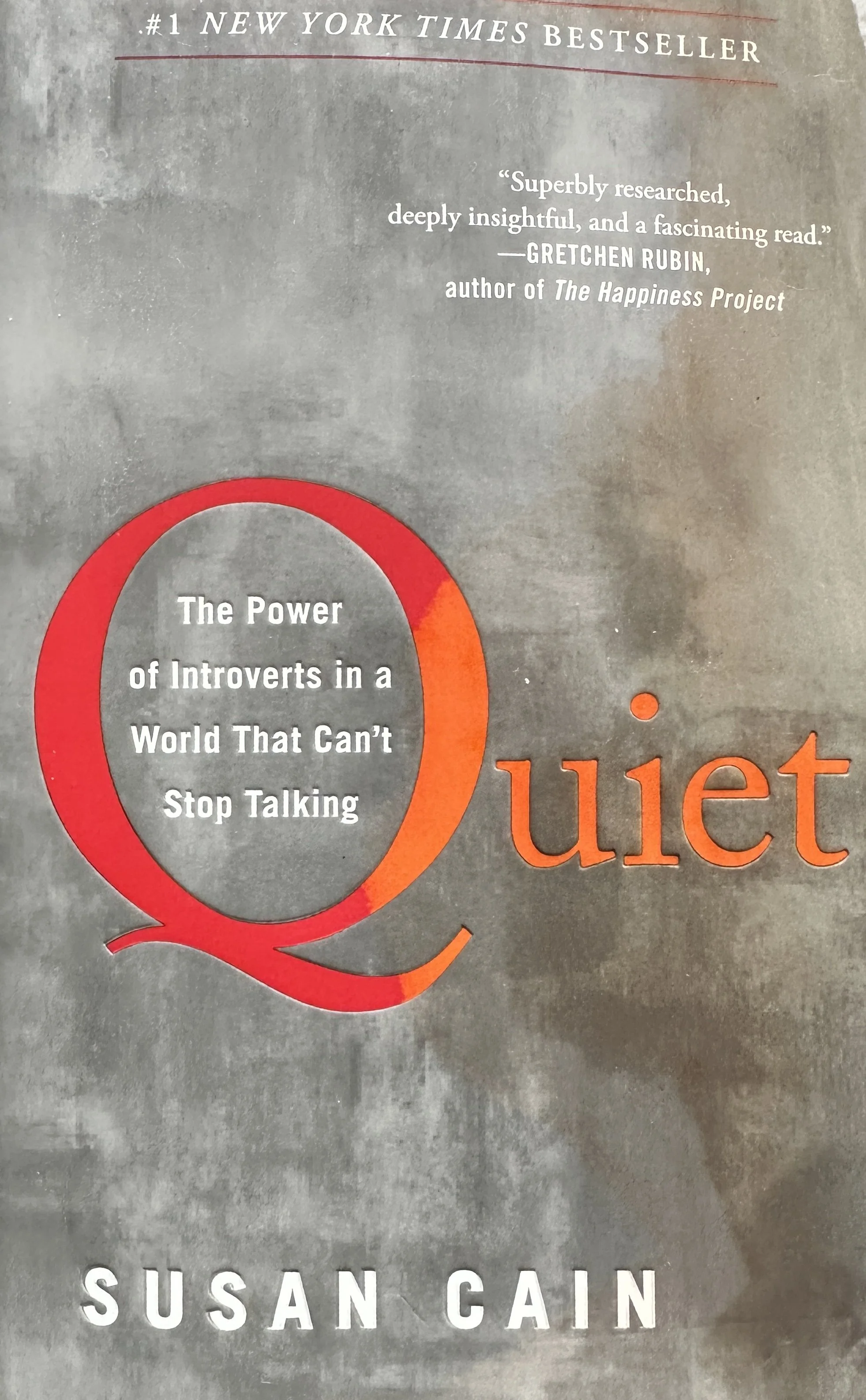 The cover of a book titled "Quiet" by Susan Cain. The subtitle reads "The Power of Introverts in a World That Can't Stop Talking." The cover features a large red and orange speech bubble with the quote "Superbly researched, deeply insightful, and a fascinating read" attributed to Gretchen Rubin. It also mentions that the book is a #1 New York Times Bestseller.