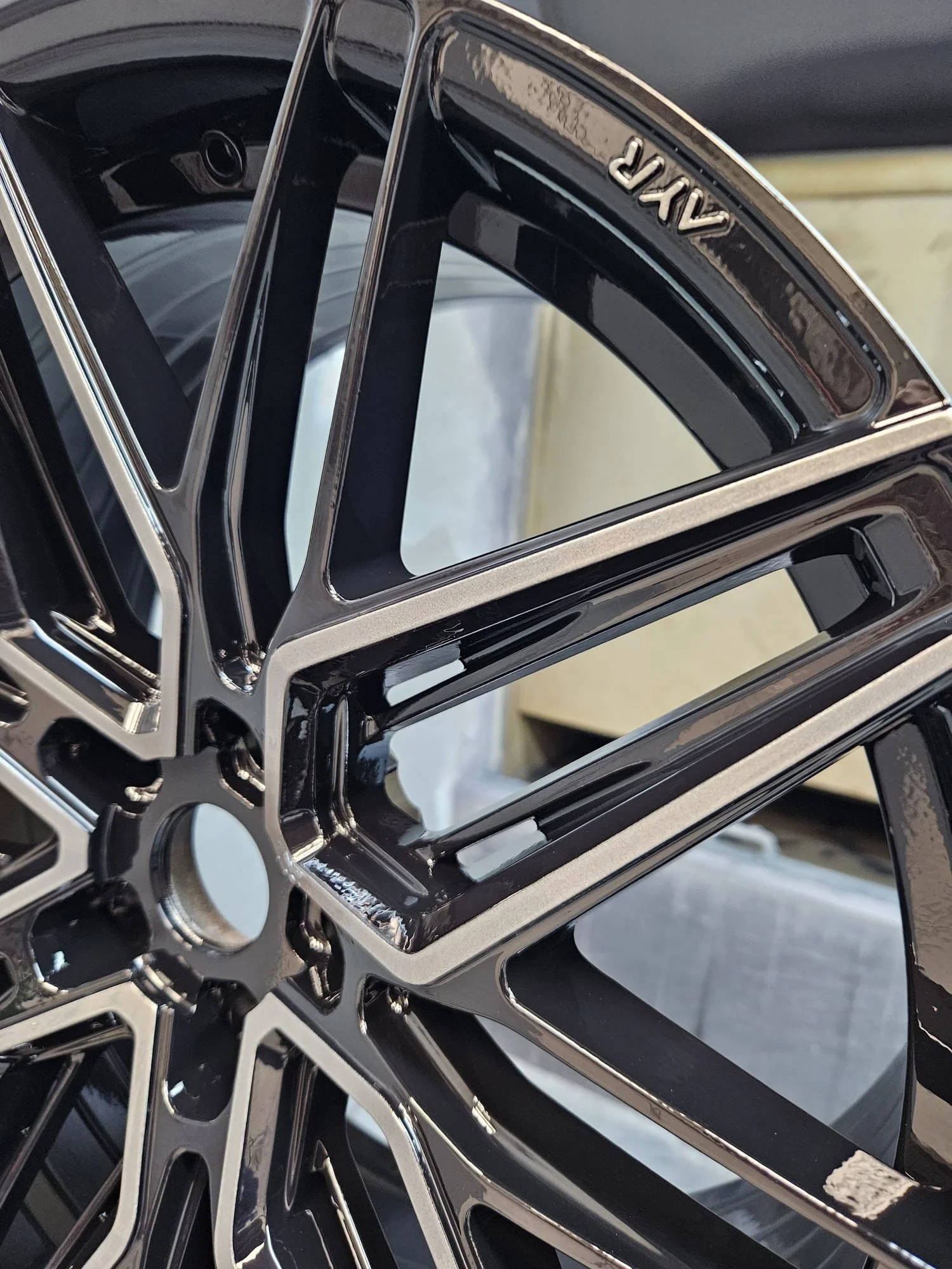 Close-up of a black and silver car rim with a multi-spoke design.