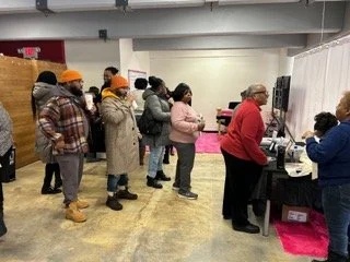 People standing in line at a service desk in an indoor setting.