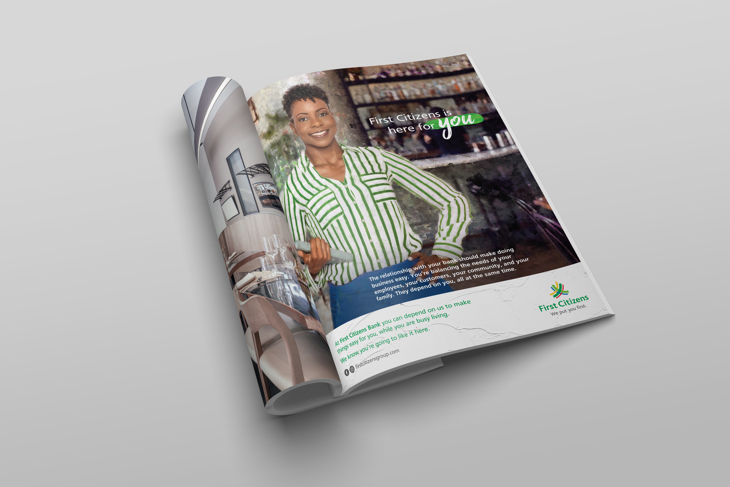 An open magazine featuring an advertisement for First Citizens Bank. The page shows a smiling woman with short curly hair, wearing a green and white striped blouse, standing in a cafe or restaurant, holding a tray. The text on the page emphasizes community and customer dependency, with the bank's logo and slogan at the bottom.