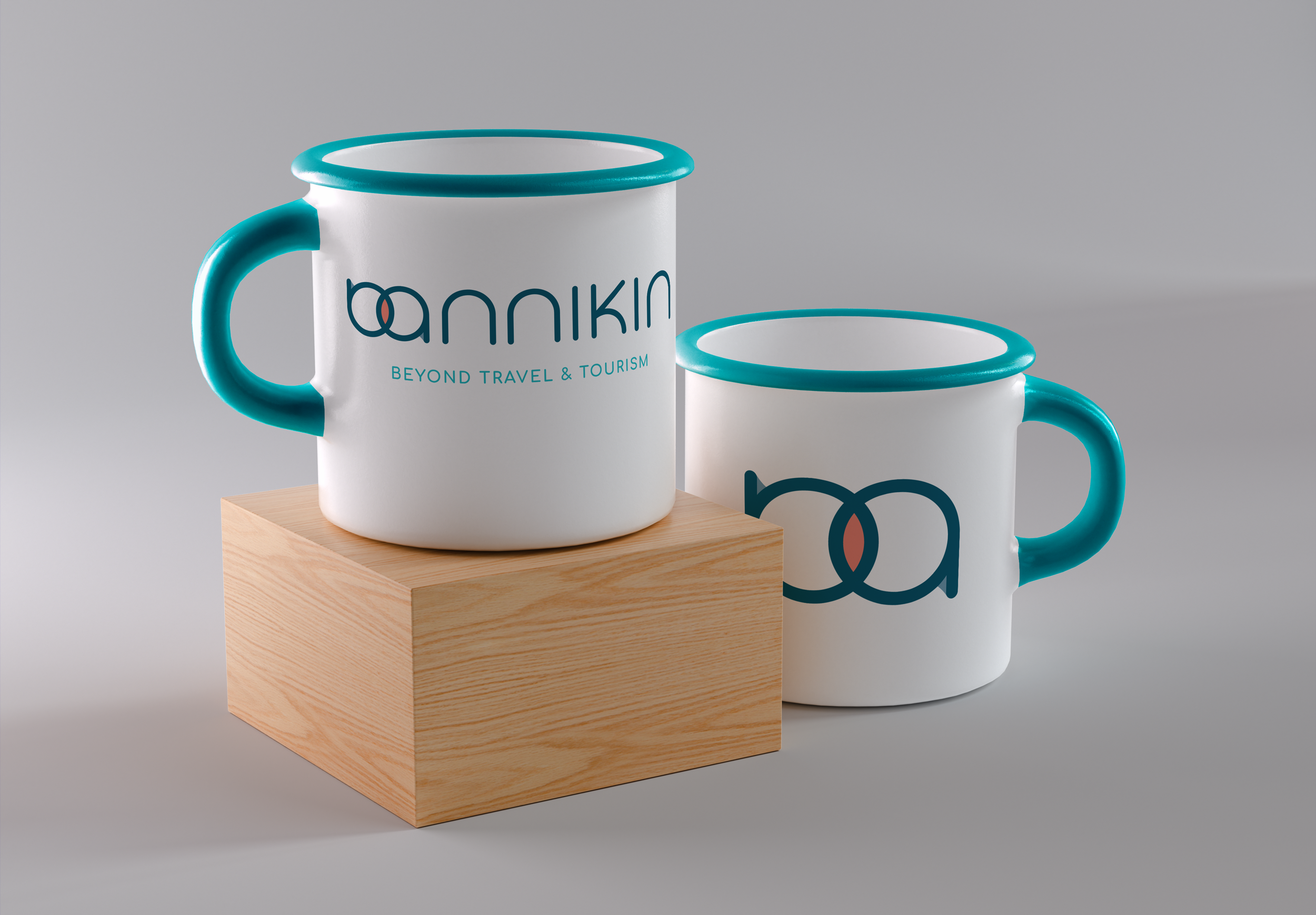 Two white ceramic mugs with teal handles and rims, featuring a logo and text, one placed on a wooden block and the other on a gray surface.