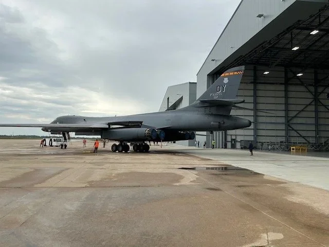 A B1 Bomber next to a large hangar