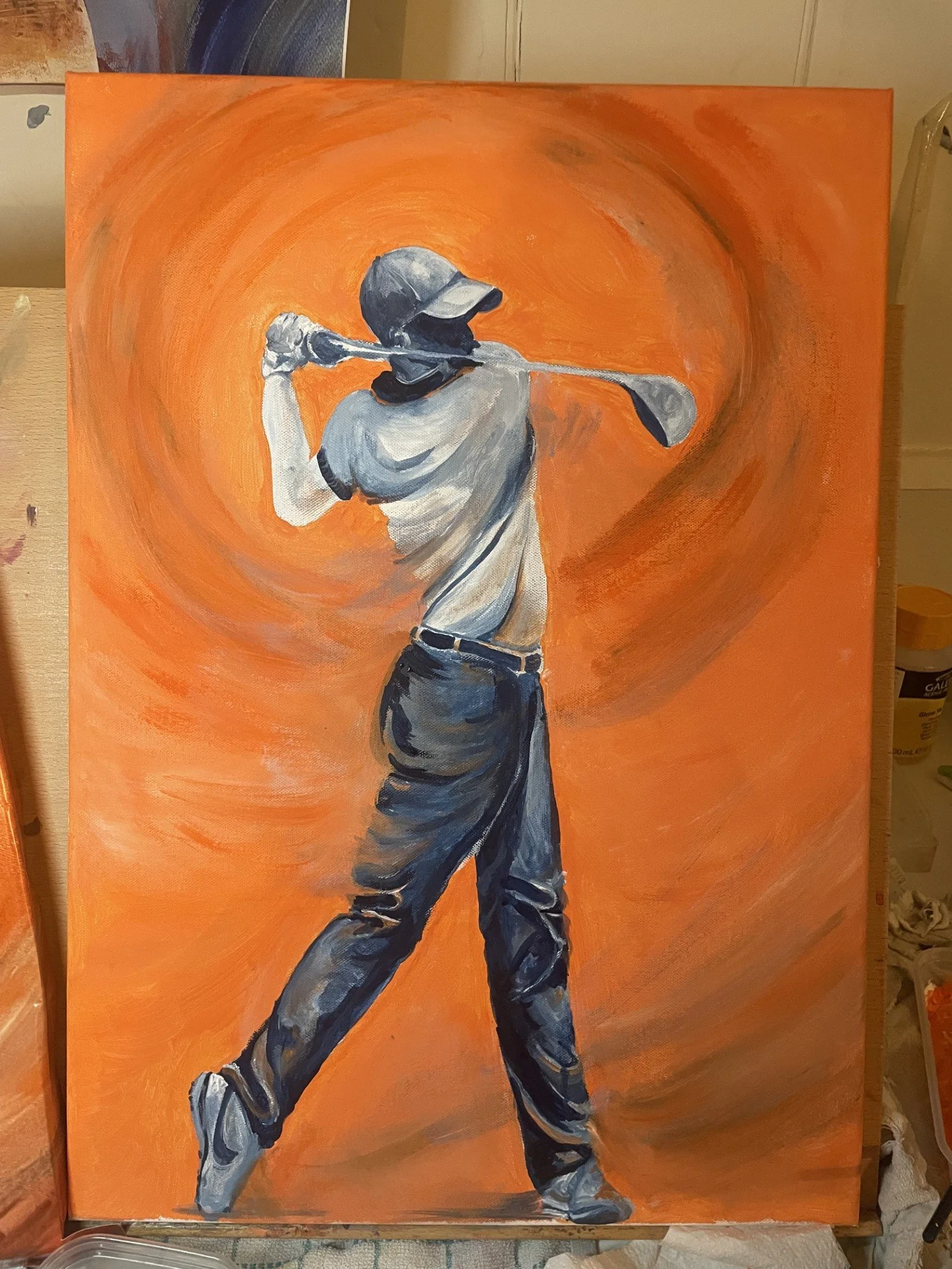 Painting of a golfer in mid-swing, wearing a cap and casual golf attire, with an orange background.