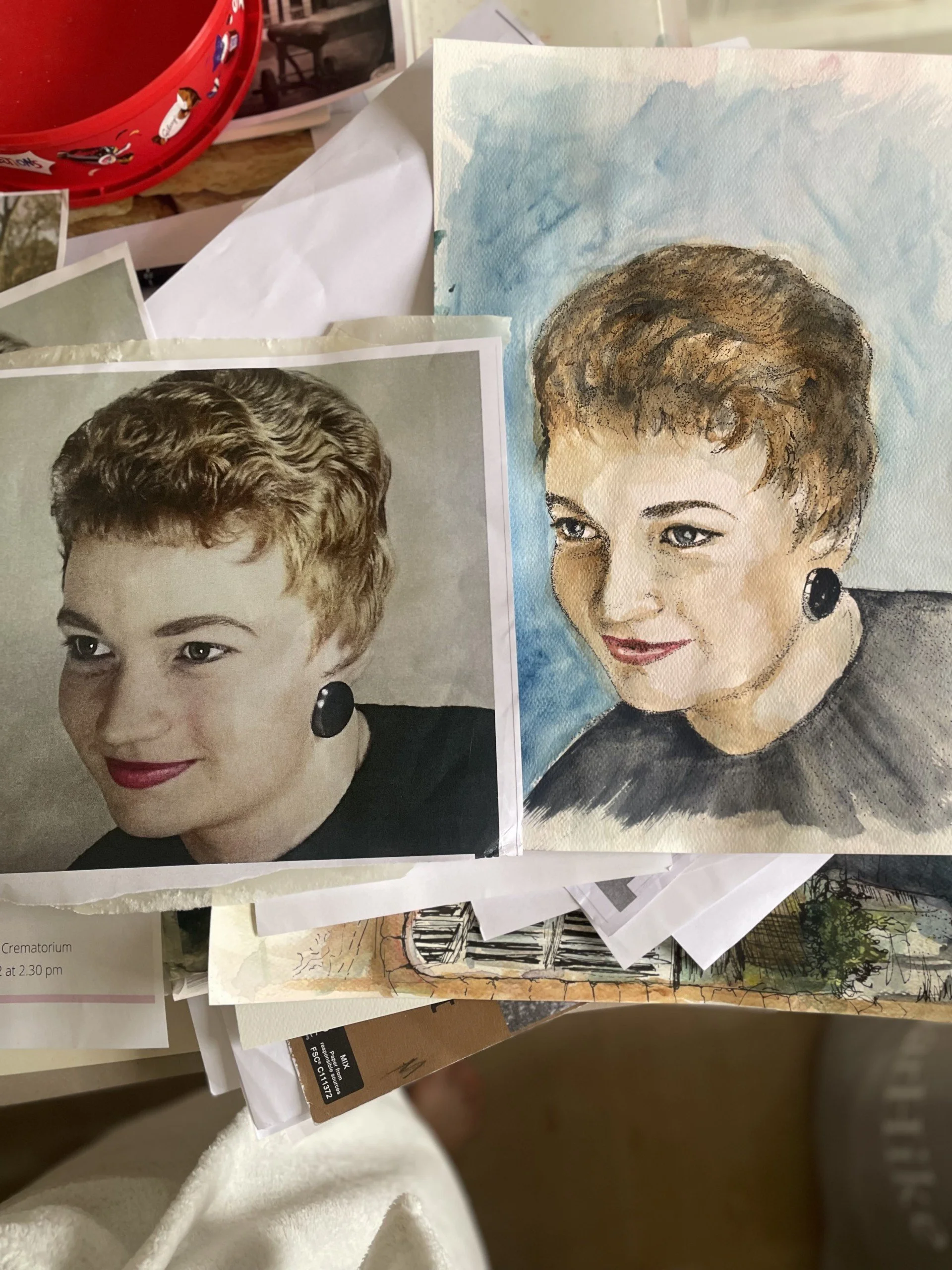 Photograph of two portraits of women, one in black and white and one in watercolor, depicting the same woman with short hair, earrings, and similar facial expression.