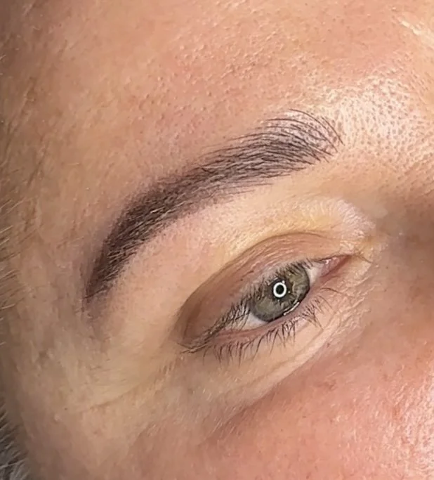 Close-up of a person's eye with well-shaped eyebrow and light skin.