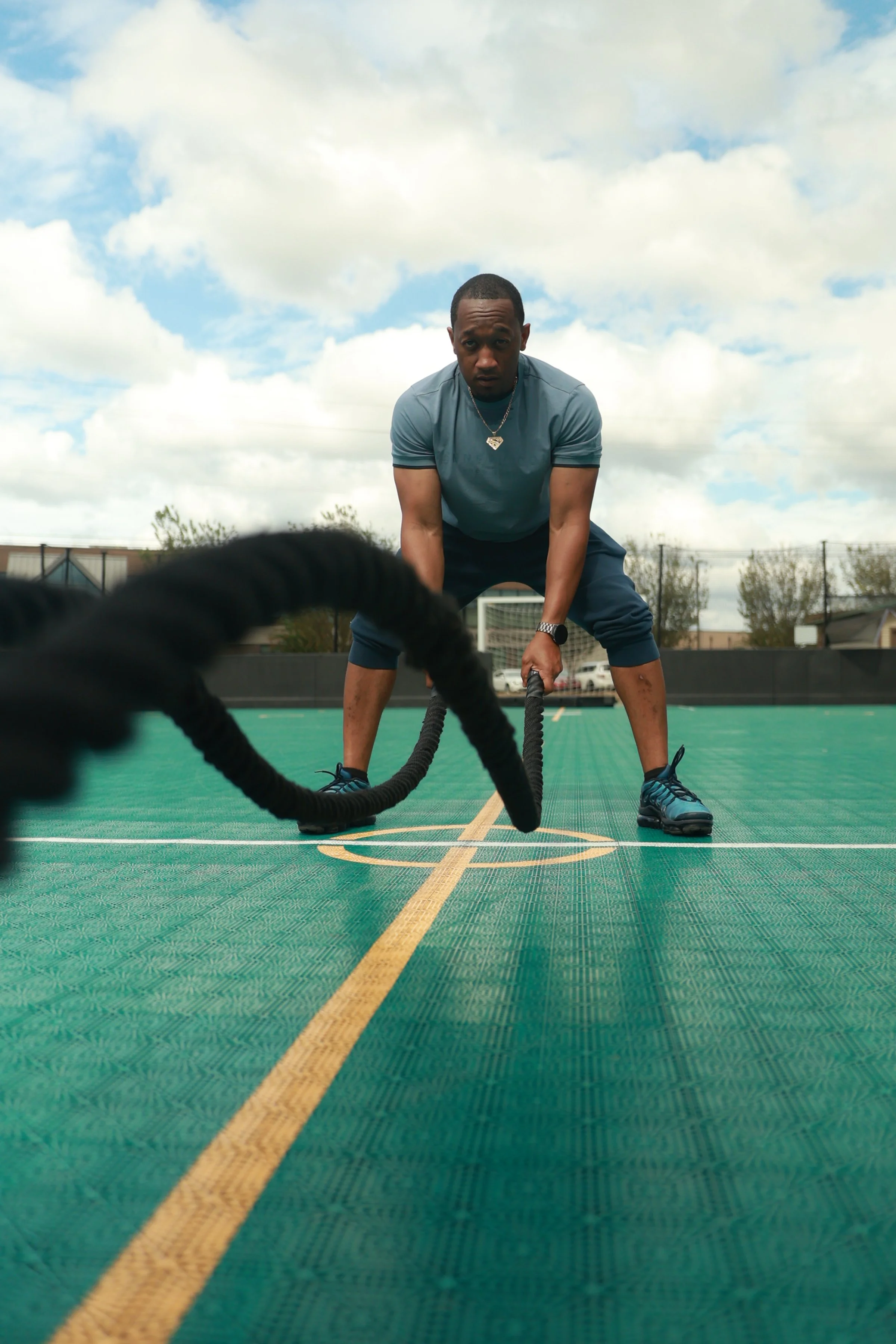 Coach Jay performing a battle rope workout during functional fitness training in Birmingham, Alabama
