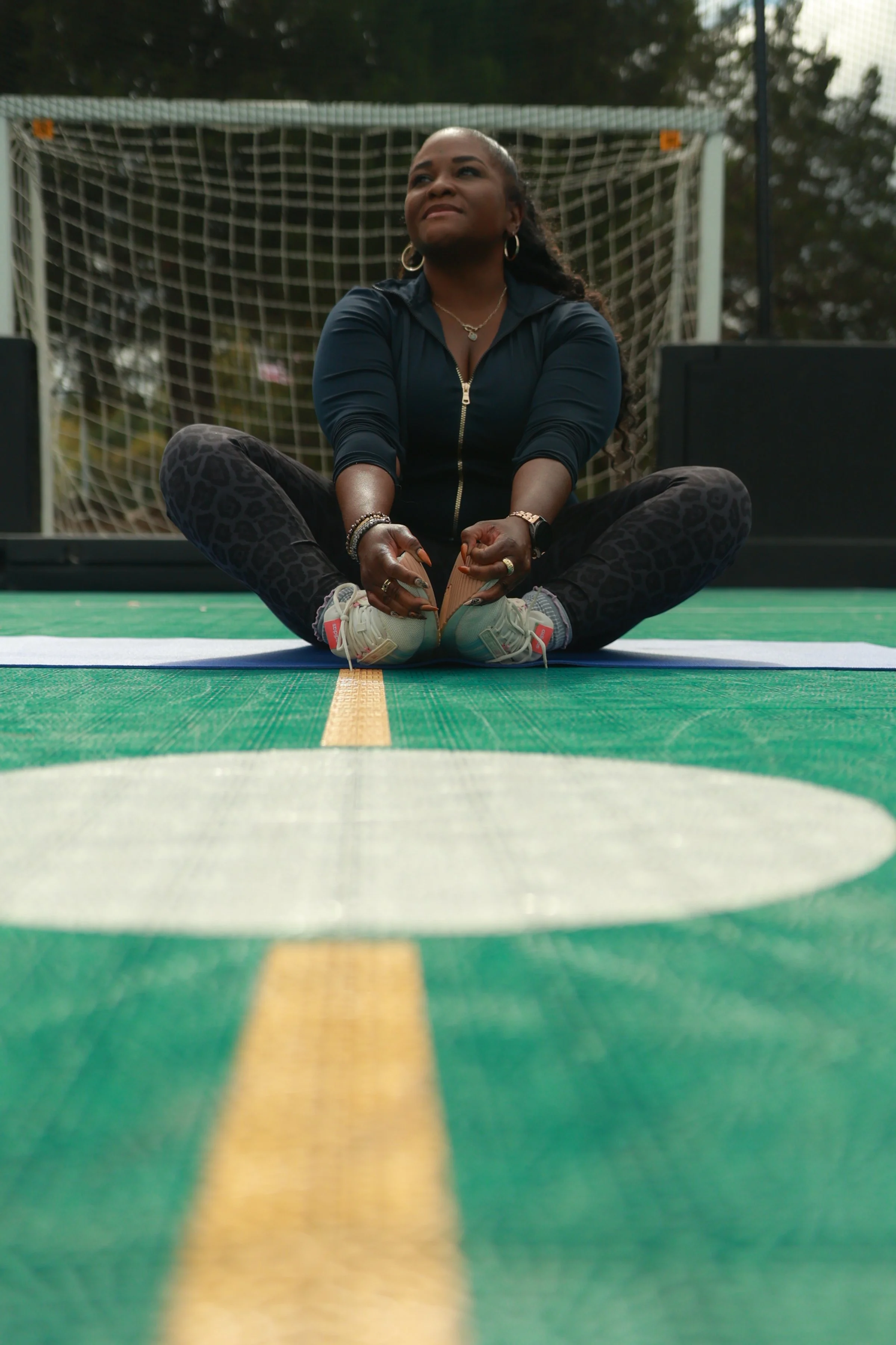 Coach Tazz seated on an exercise mat during a women’s wellness fitness session in Birmingham, Alabama