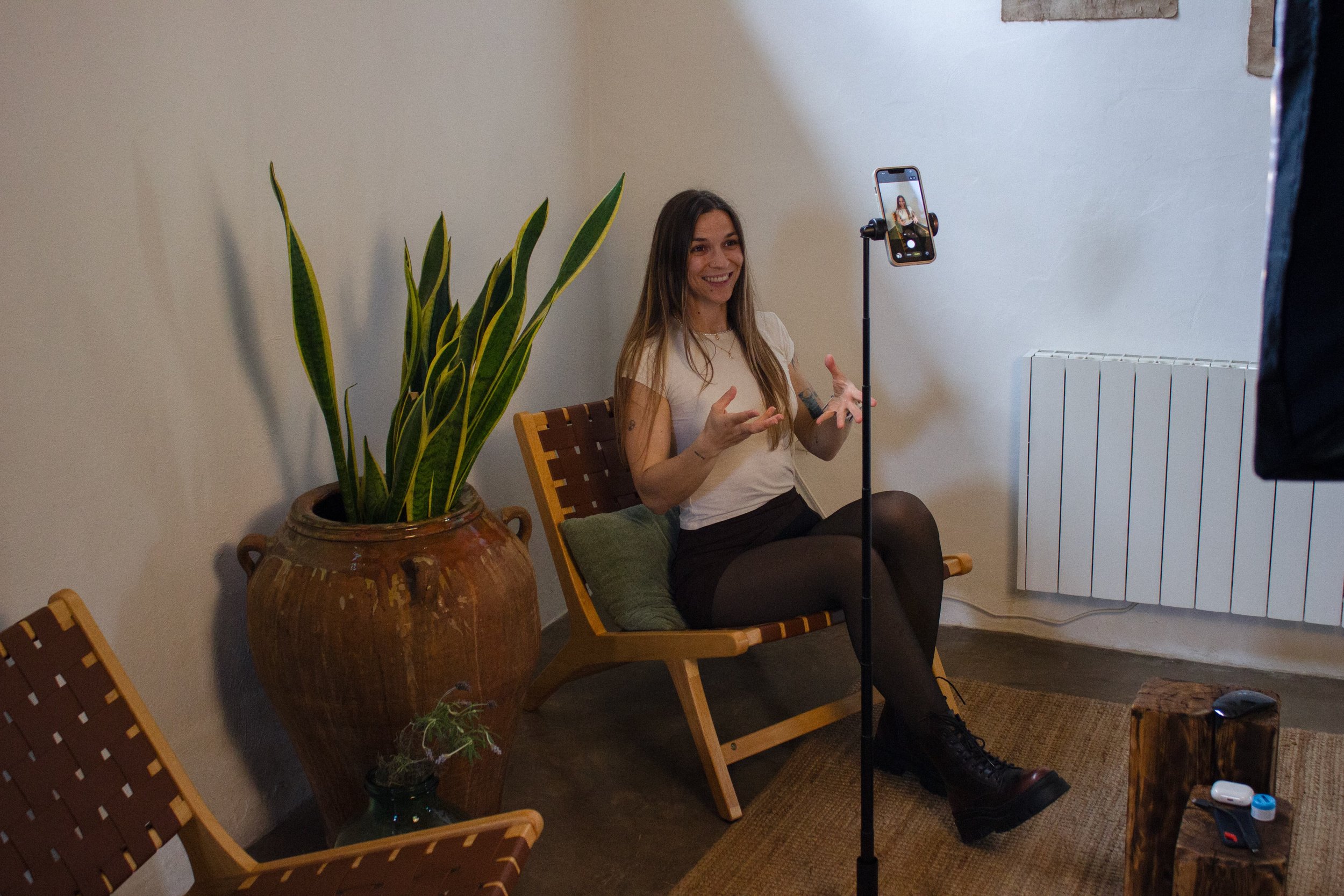 A brand identity and Squarespace designer, founder of Artentii Designs talking in front of a camera. She is filming content for her socials in order to build trust with her community and get more high-paying clients for her brand and website services