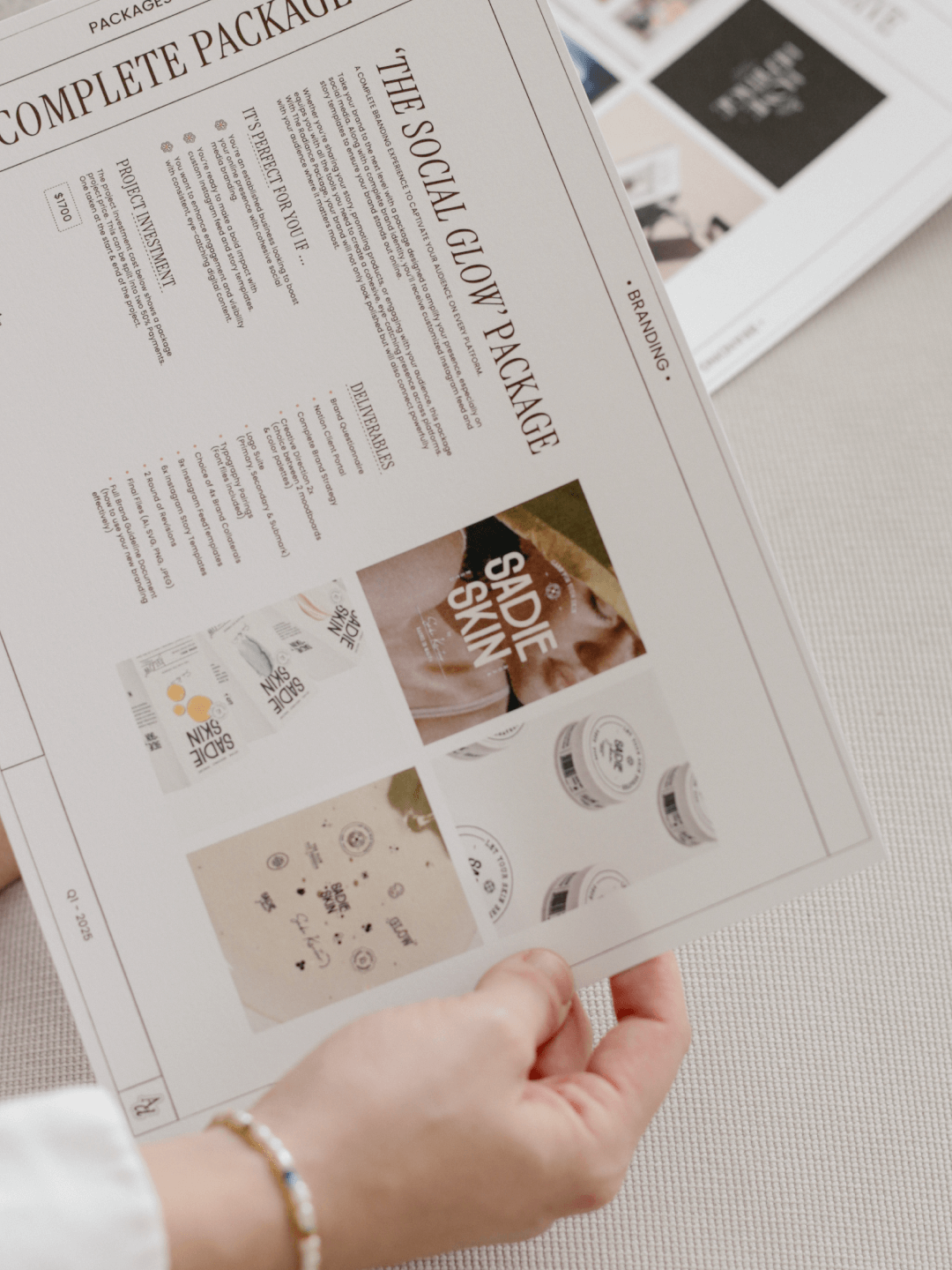 A person holding a printed marketing sheet advertising packaging solutions, titled 'The Social Glow' Packaging, with images of product packaging and promotional designs.