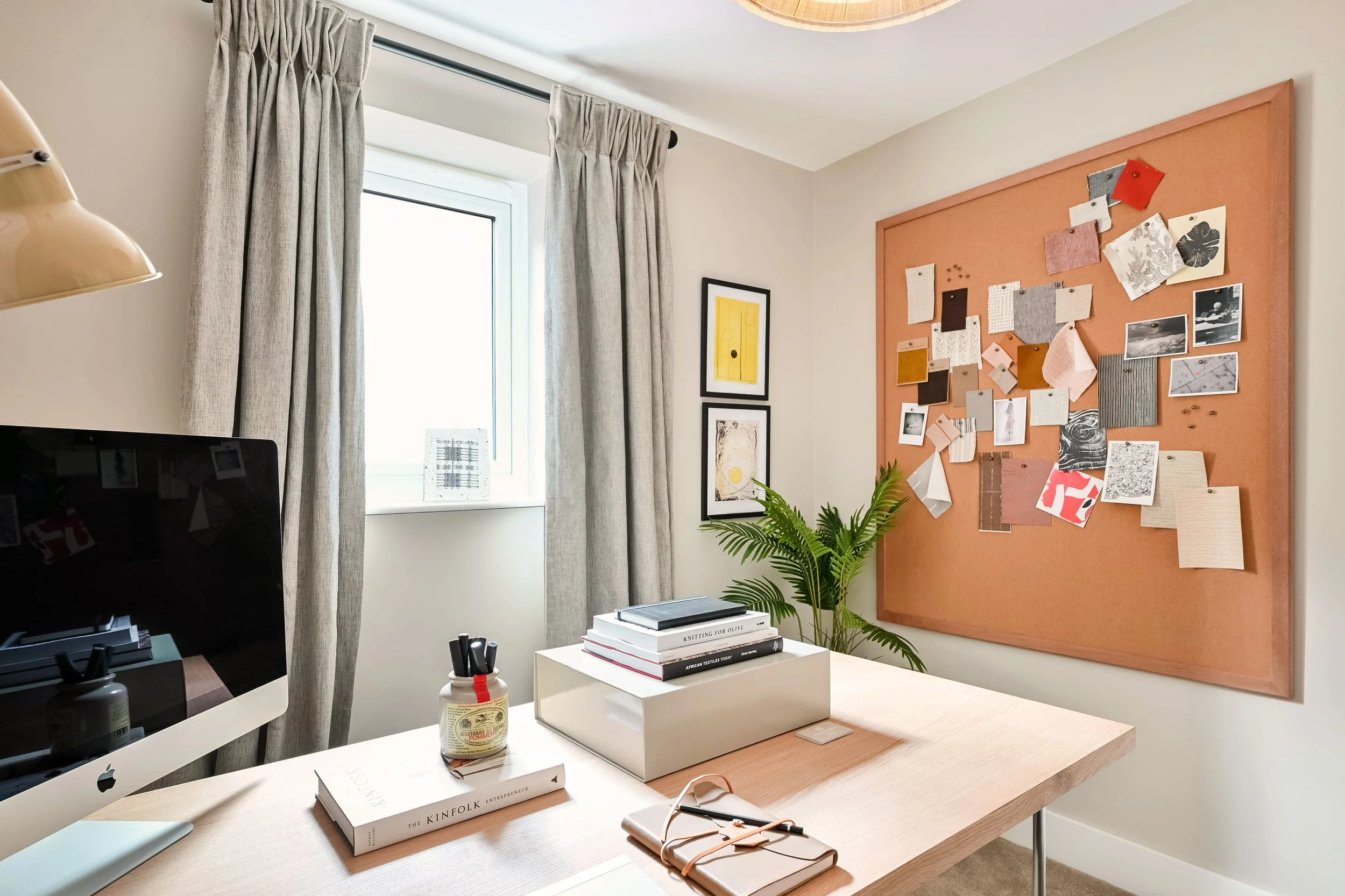 Creatively laid out show home office space with large wall corkboard