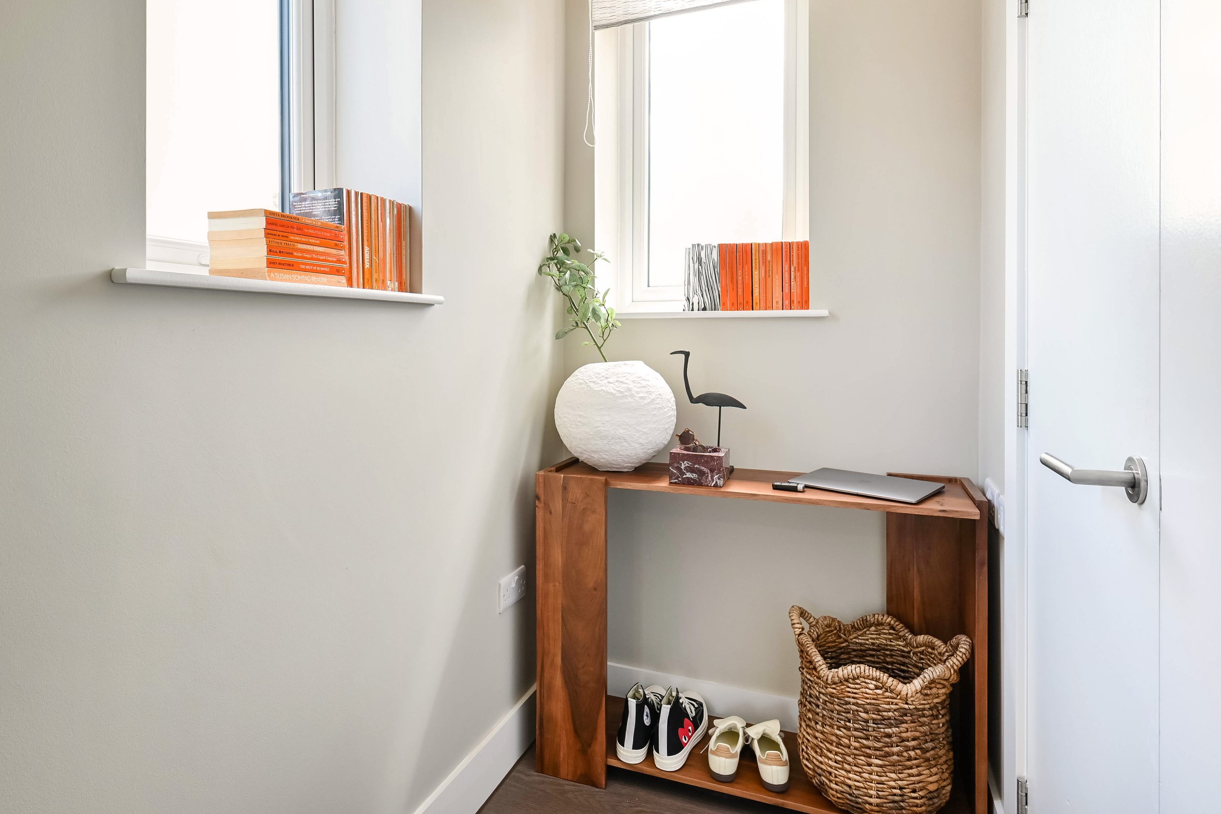 An uncluttered and well organised entrance hall with console table and storage basket