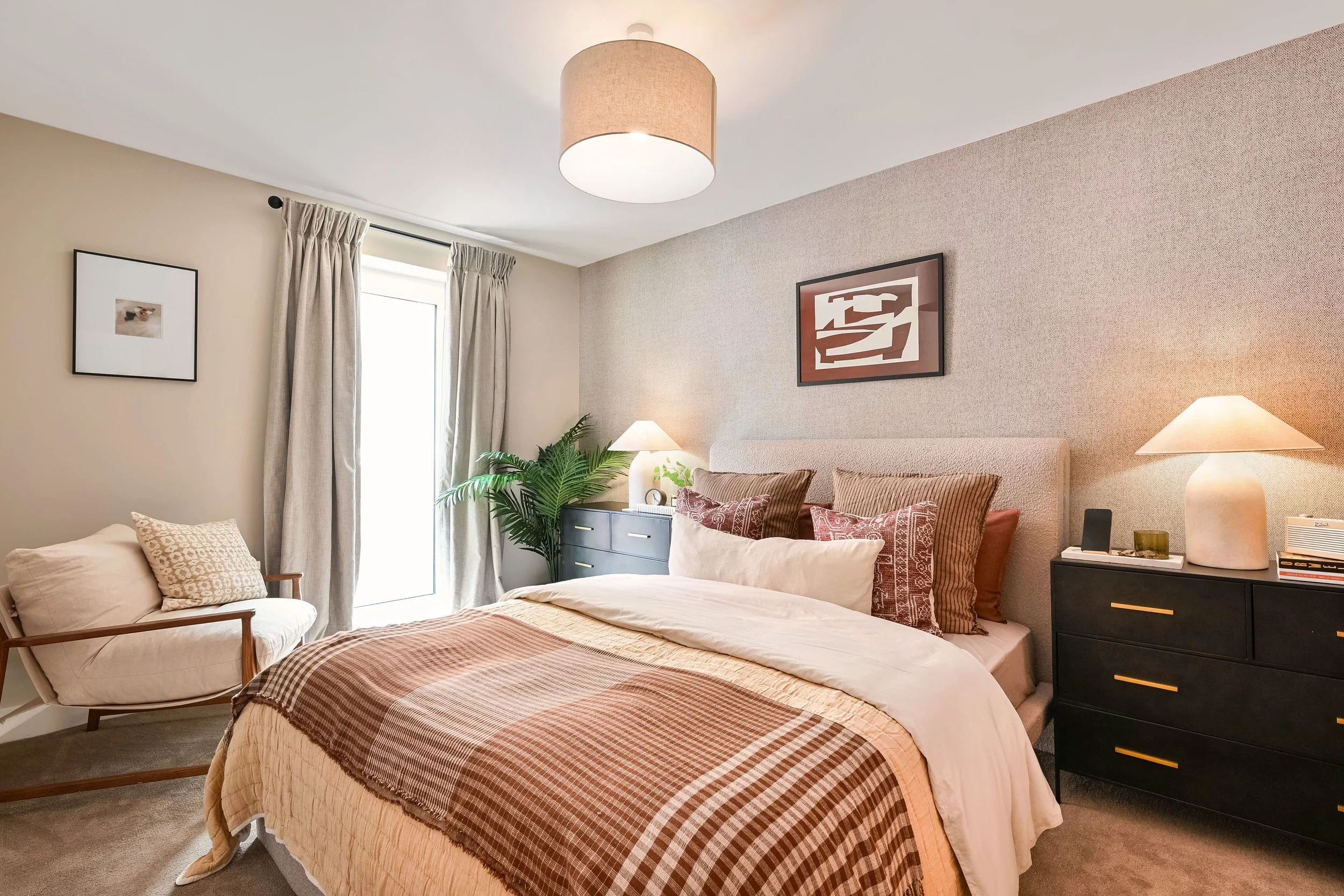 A brown checked throw on a spare bed in a show home styled bedroom