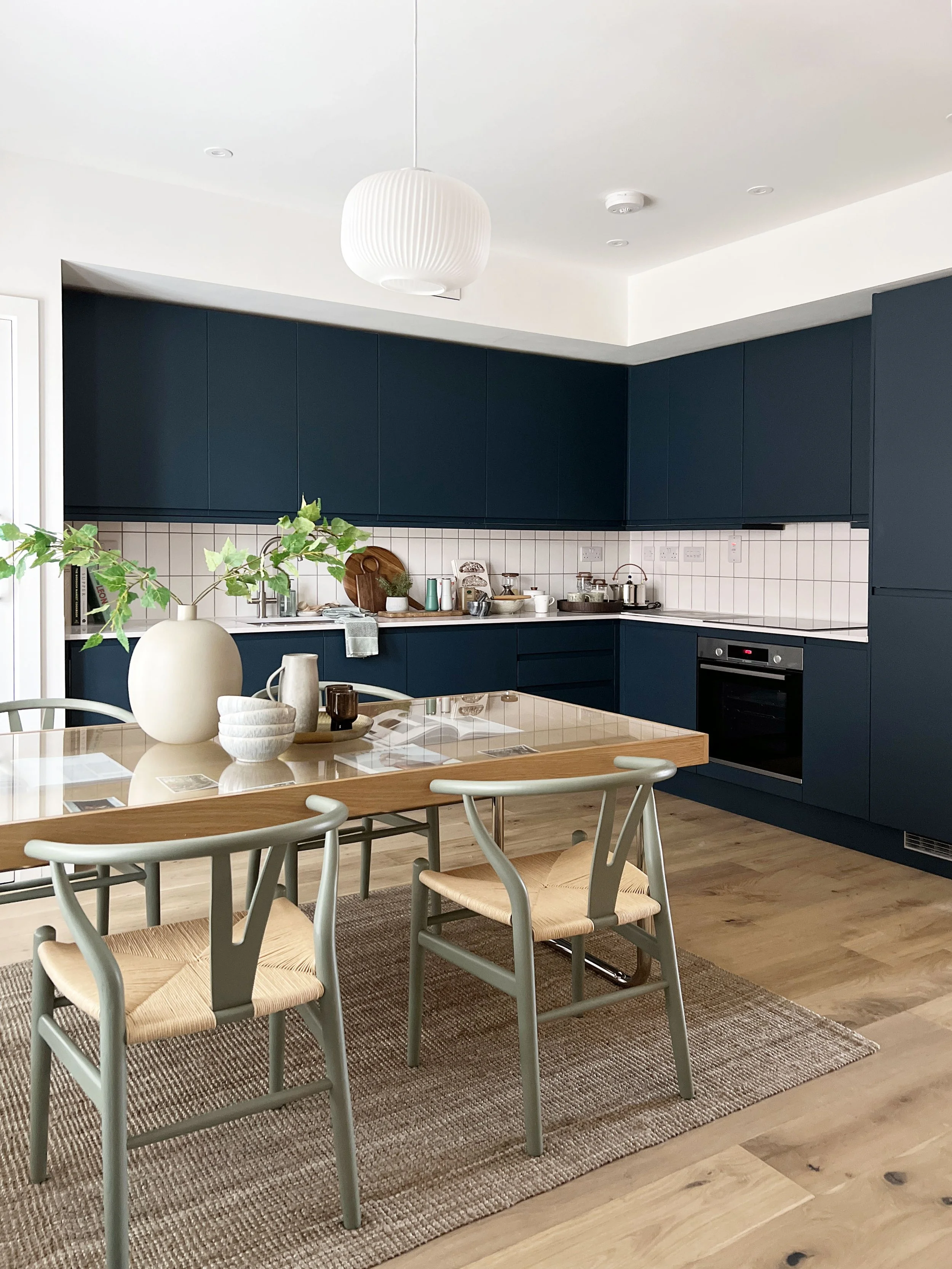 A dark charcoal kitchen with contrasting and inviting dining area