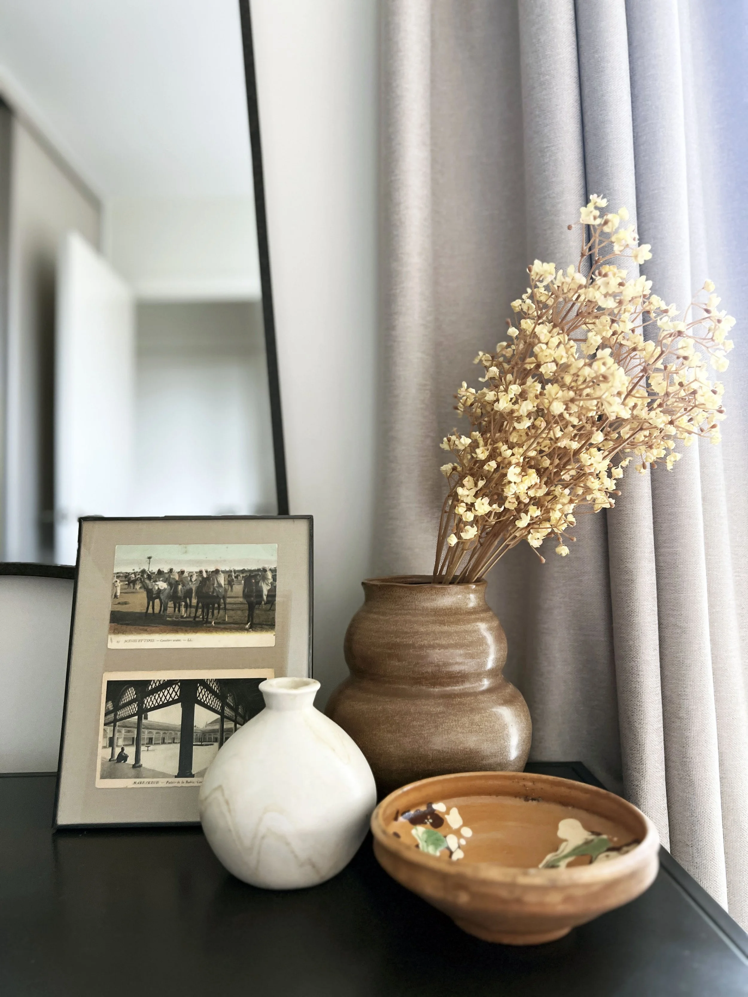 Small accessories on a table, complete with a vase and dried flowers