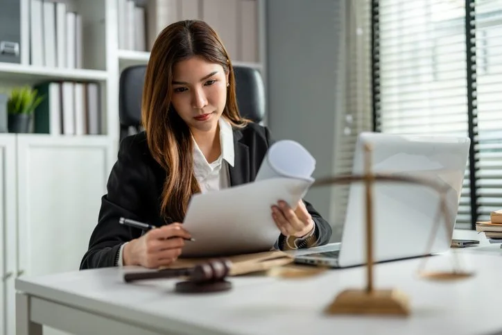 Female lawyer sitting at desk analyzing a report
