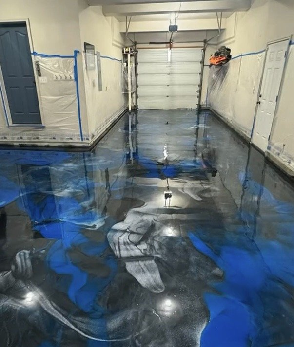 A garage with newly poured polished concrete floor that has a blue tint.