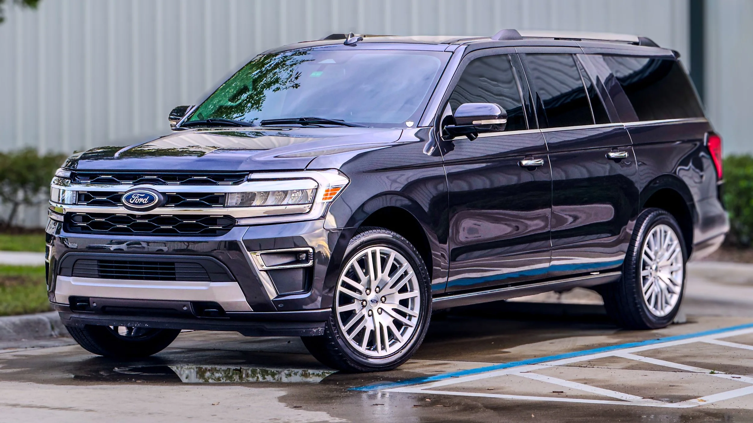 Black Ford SUV parked in a parking lot next to a curb.