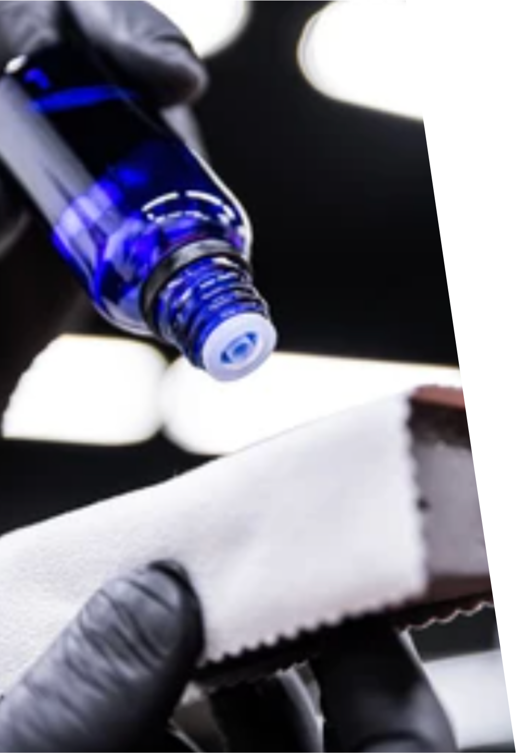 Detailer applying a ceramic coating from a blue bottle to an applicator