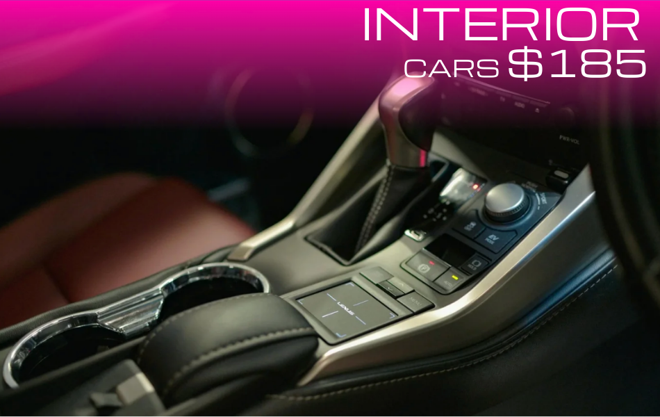 Close-up view of a luxury car interior center console with gear shift, control buttons, and cup holders, featuring leather details and modern design.