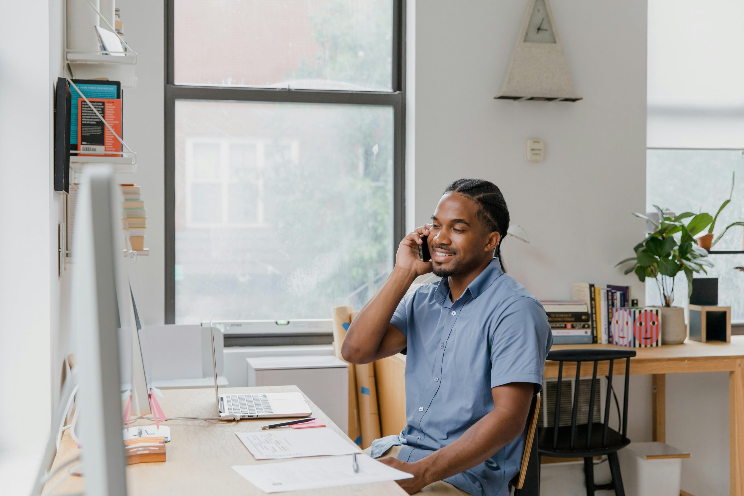 Business owner sitting at desk talking on phone