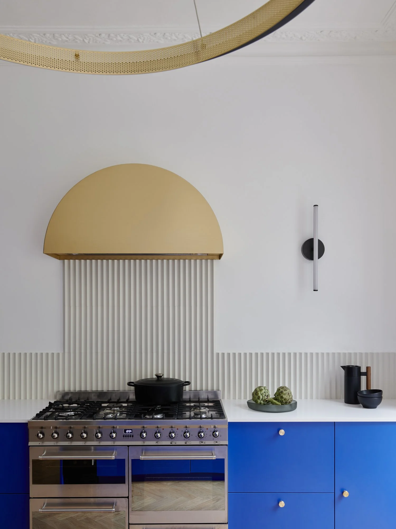 Modern kitchen with blue cabinets, a gas stove, and black and wood accessories