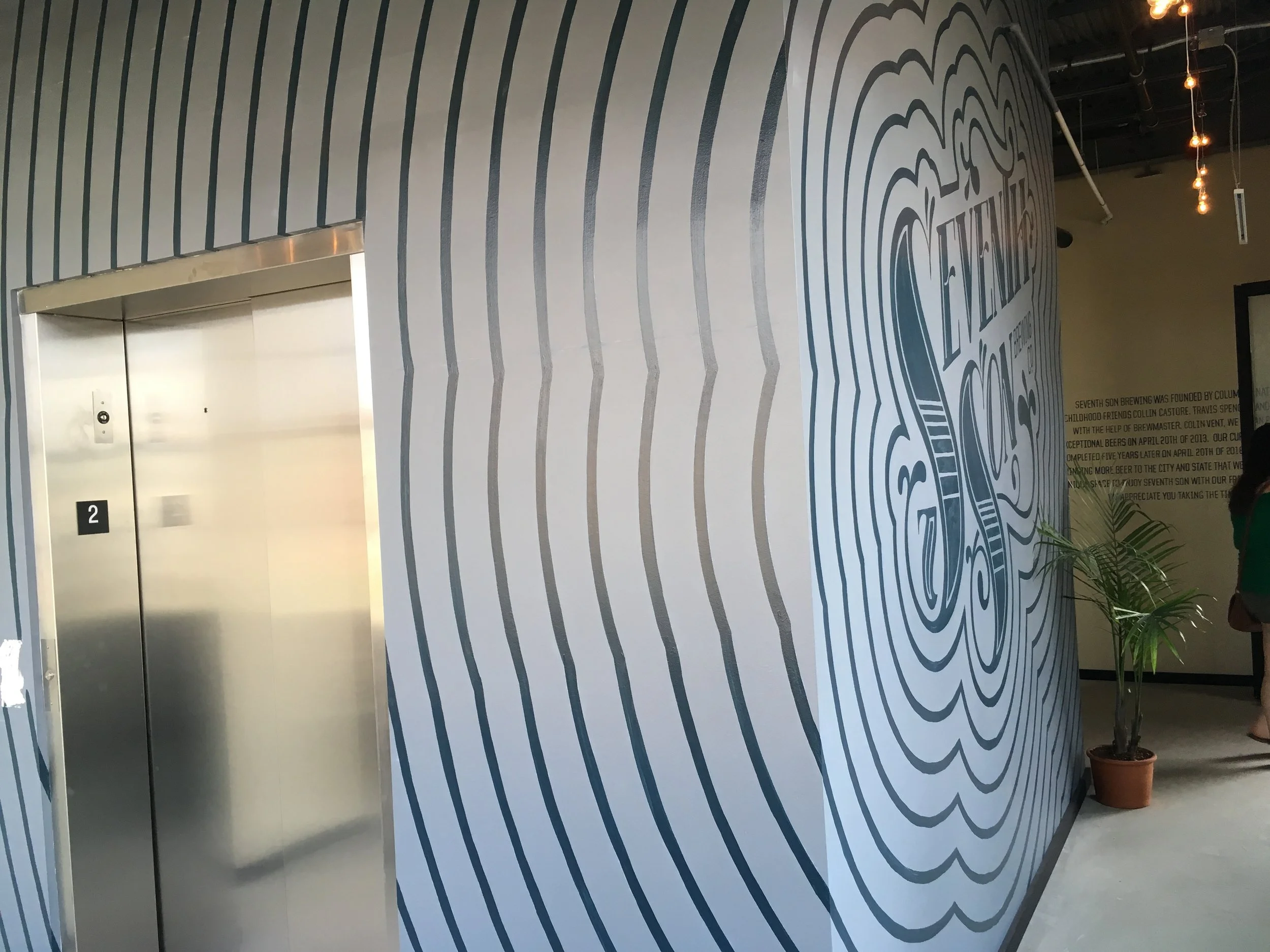 Hand Painted logo and radiating design wrapping around to the side wall. 
