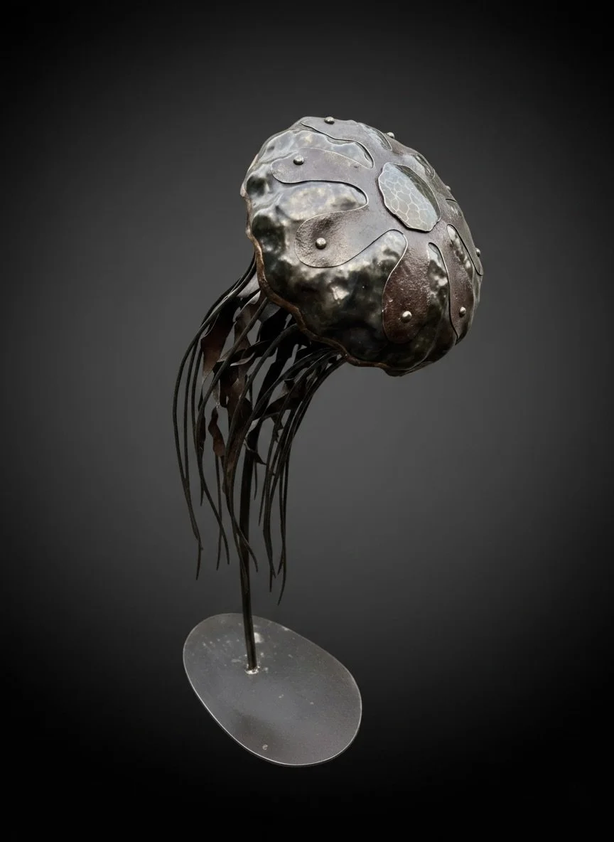 Forged and welded steel sculpture of a jellyfish on a round base.